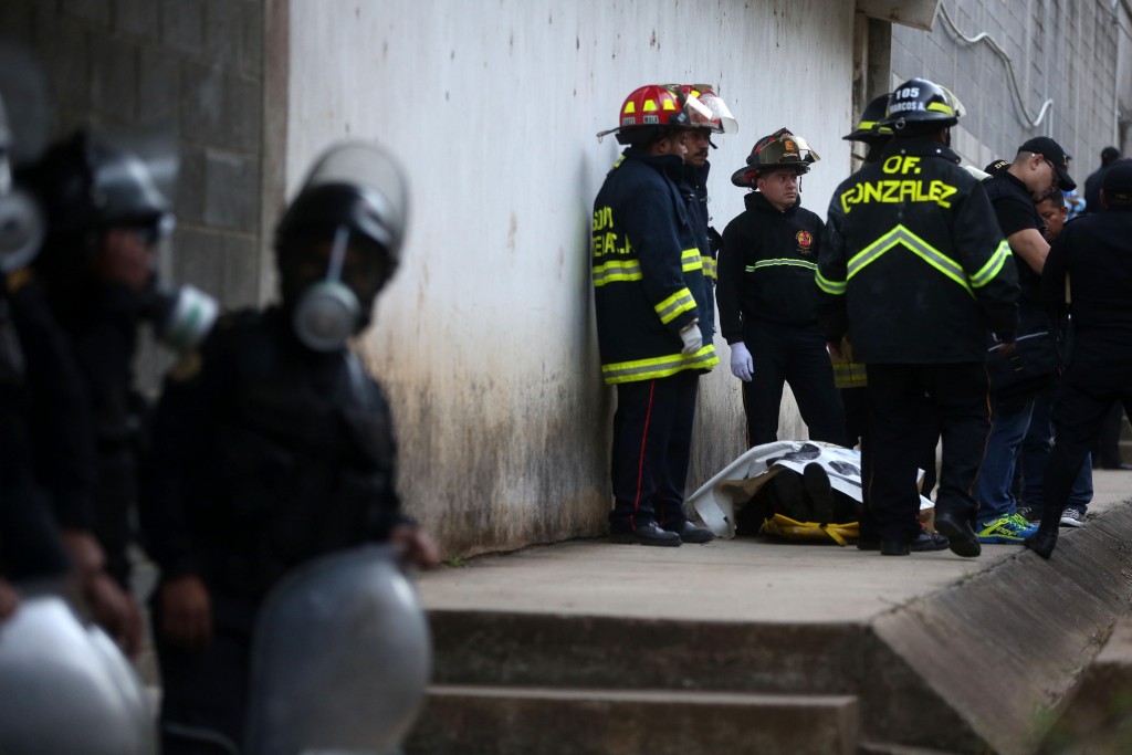 Bomberos guatemaltecos permanecen junto al cuerpo del monitor fallecido (EFE)