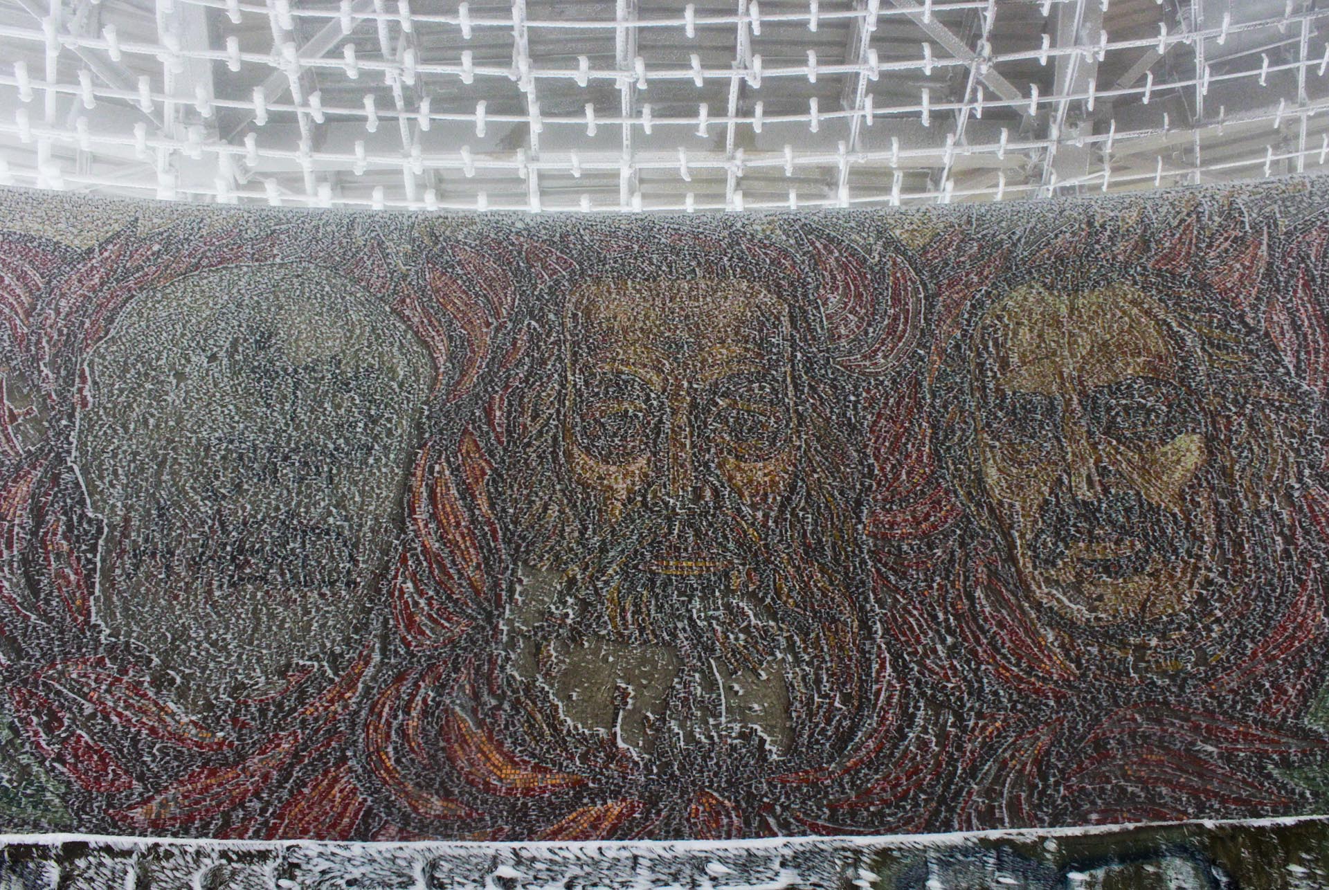 Mosaicos en el auditorio central con los rostros de Dimitar Blagoev (el primer socialista de Bulgaria, a quien el edificio rinde culto), Georgi Dimitrov (el primer presidente socialista, desde 1946 hasta su muerte en 1949). El primero de la izquierda, desdibujado, es el rostro de Todor Zhivkov. líder del régimen desde 1954 hasta la caída en 1989. El edificio se inauguró bajo su mandato
