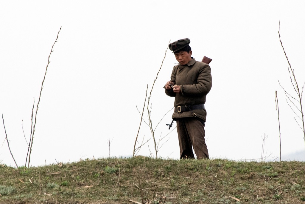 Un soldado prepara un cigarrillo cerca al río Yalu. A pesar de que el domingo el régimen comunista llevó a cabo un lanzamiento de misil fallido, los soldados que se ven desde los barcos chinos parecen muy tranquilos