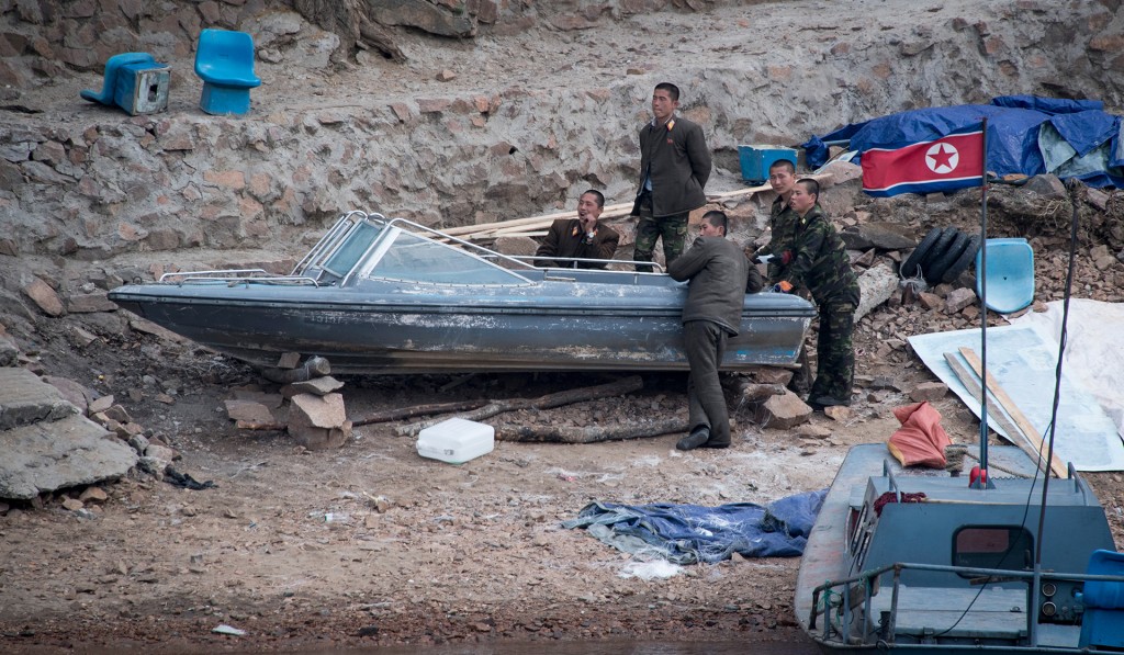 Soldados norcoreanos descansan junto a un bote a las orillas del río (Fotos: AFP)