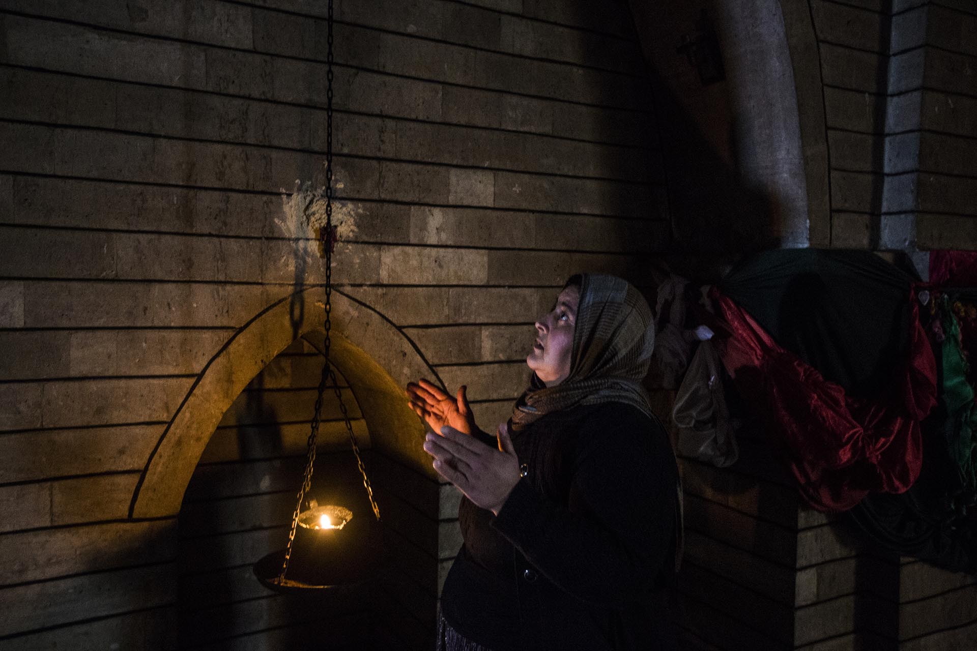 Una mujer reza en el interior del templo sagrado situado en las afueras de la ciudad de Lalish (Pablo Cobos)