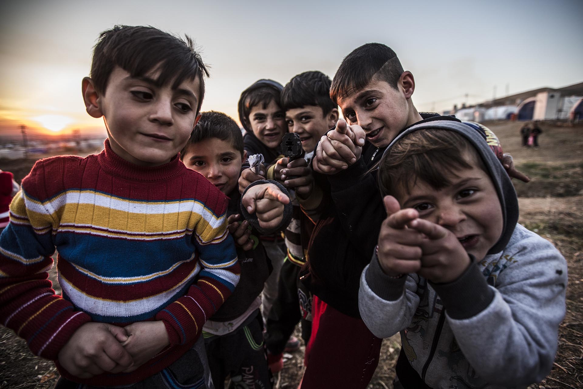 Un grupo de niños yazidíes juegan con pistolas simuladas en elcampo de refugiados de Essian (Pablo Cobos)