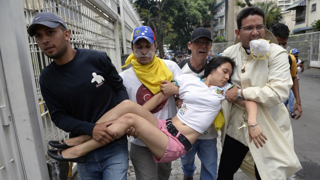 Una mujer que fue afectada por la represión es trasladada en Caracas (AFP)