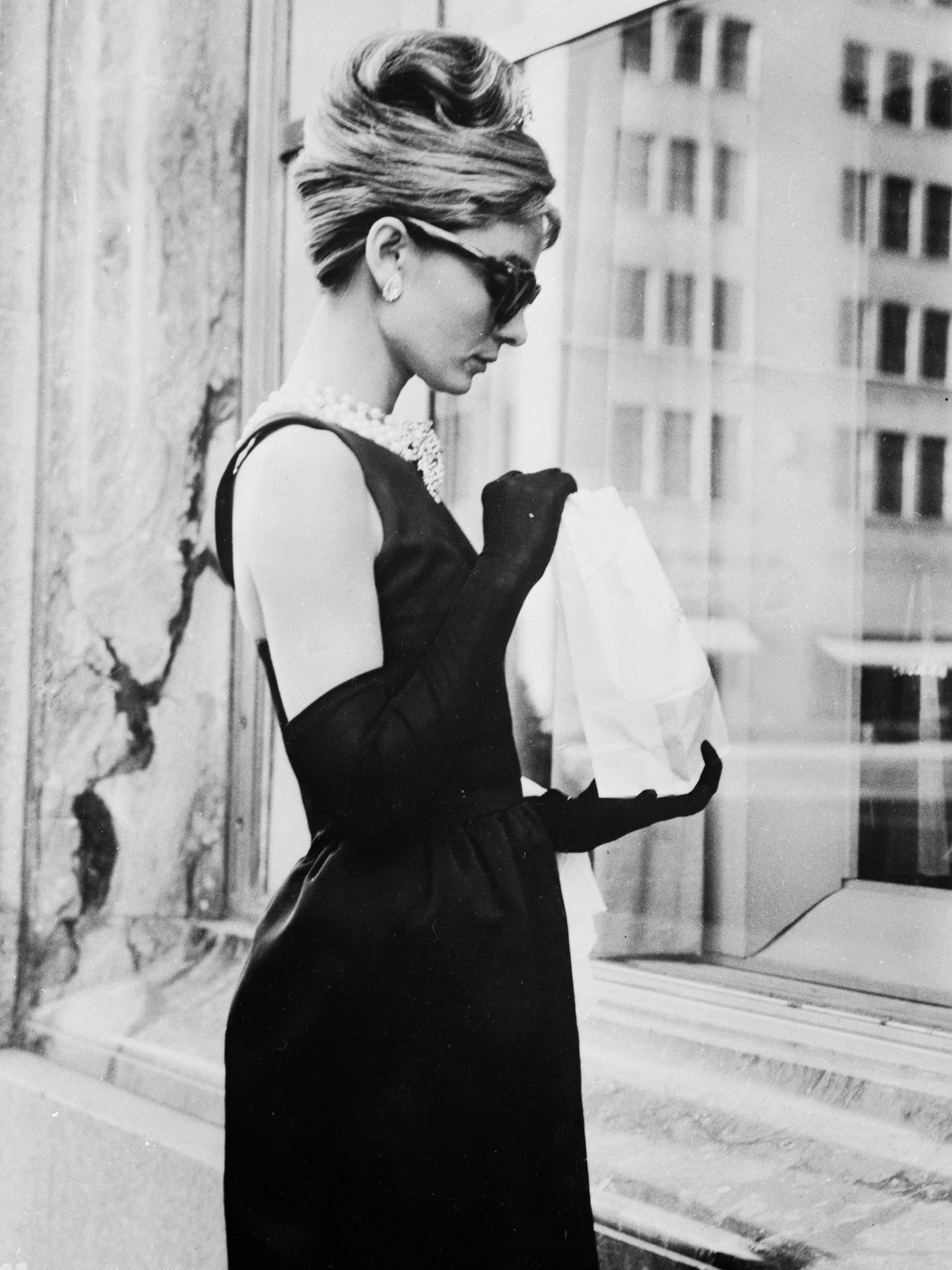 Audrey Hepburn filamando ‘Desayuno en Tiffany’ en 1961, un film que la catapultó a la fama internacional. Su look: el famosos vestido negro de Givenchy con su collar de perlas y anteojos cat eye, quedó instalado en la moda (Keystone Features/Getty Images)