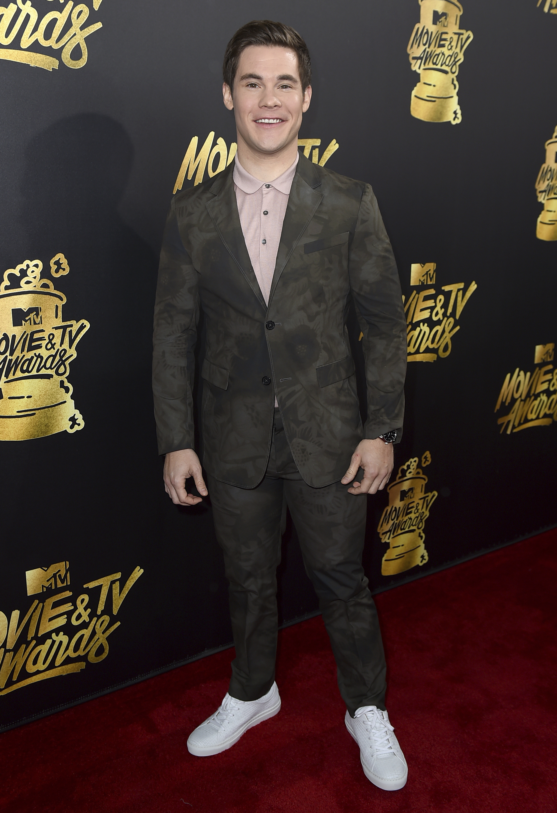 Adam Devine se puso un traje con camisa rosa y zapatillas blancas (Jordan Strauss/Invision/AP)