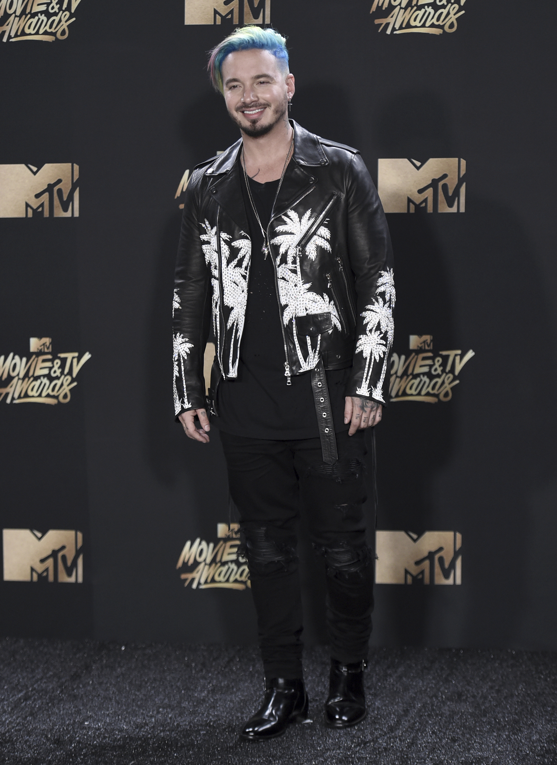 J Balvin estuvo presente en la alfombra roja con pantalones oscuros, remera oscura y campera de cuero con palmeras blancas (Richard Shotwell/Invision/AP)