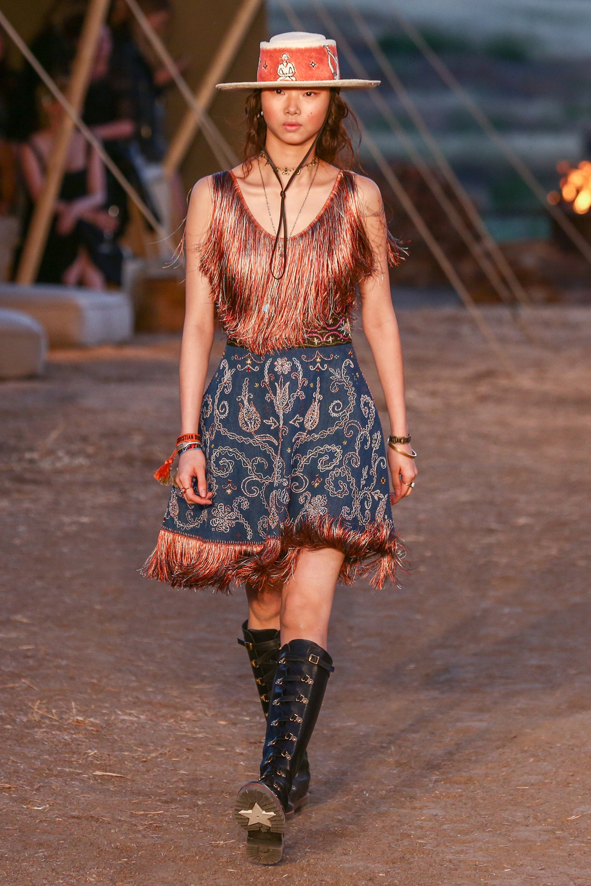 De flecos y falda estampada con borcegos de caña alta y sombrero con detalle de peluche y apliques. Pulseras rigidas y cintas (Photo by Rich Fury/Getty Images)