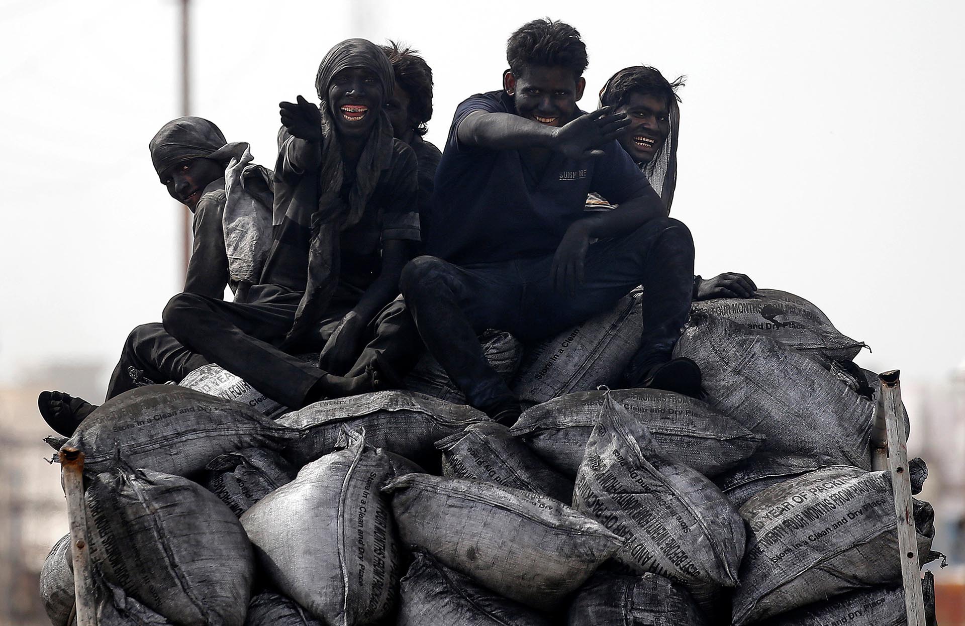Trabajadores del carbón viajan en la parte trasera de un camión en Barsana, India,