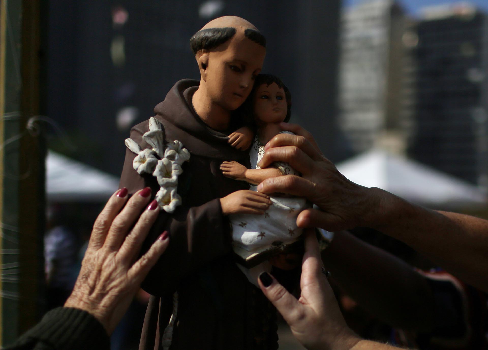 Creyentes tocan la estatua de San Antonio durante la fiesta anual de San Antonio de Padua en un convento de Río de Janeiro, Brasil