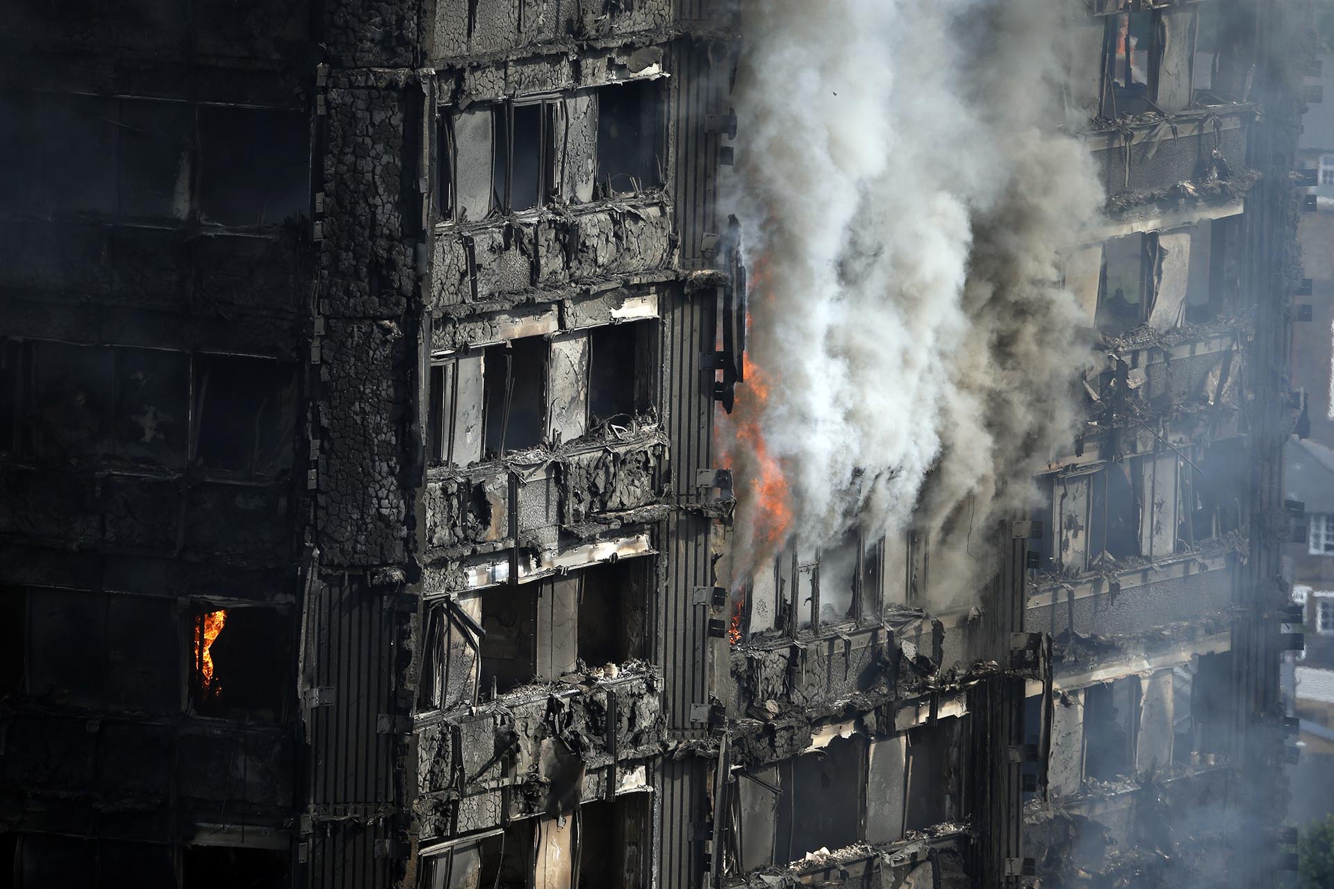 Partes del edificio todavía quemándose horas después del comienzo del incendio mortal en el bloque de apartamentos de gran altura en Londres