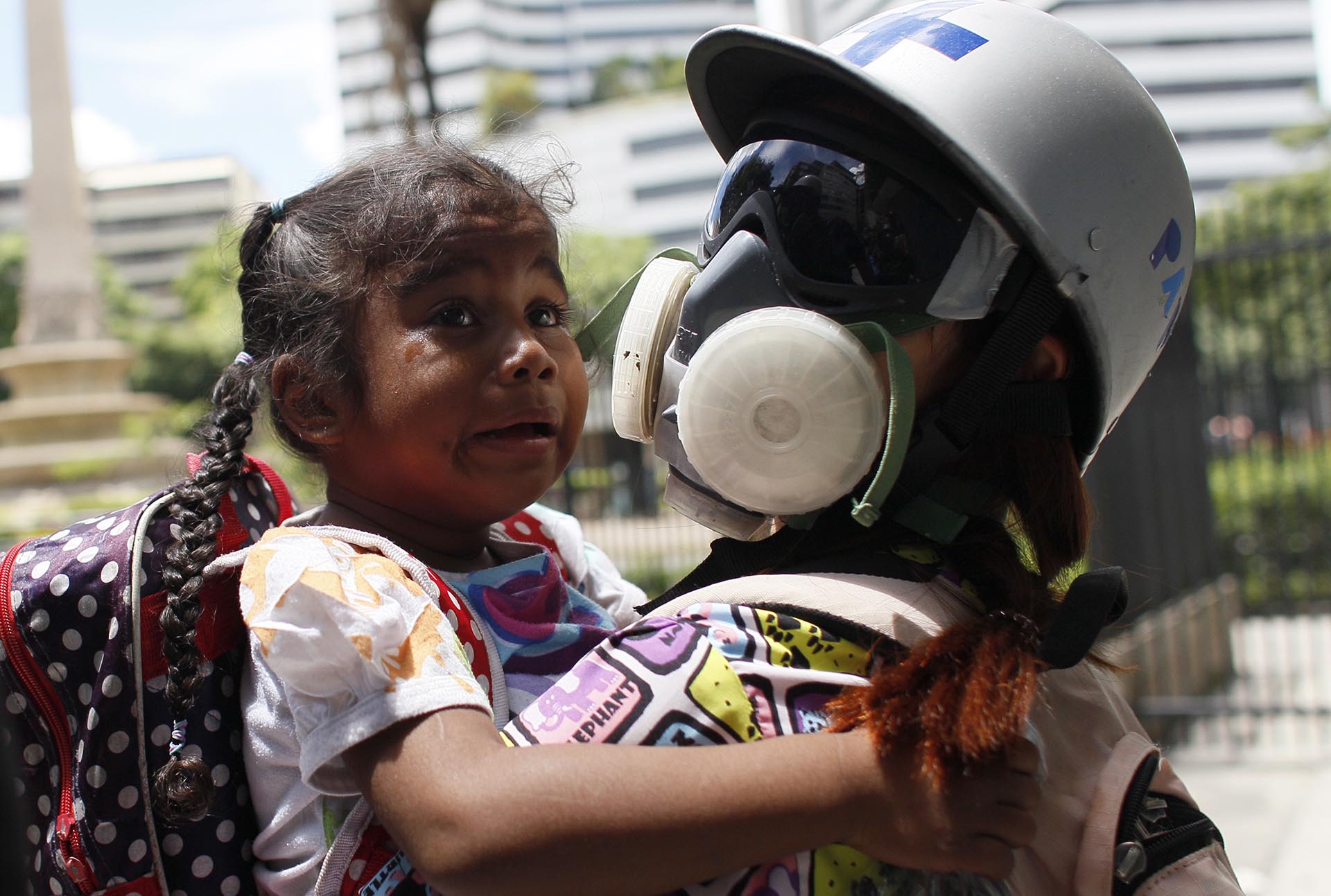 Una paramédica asiste a una niña afectada por gases lacrimógenos durante la represión chavista a una manifestación opositora en Caracas, Venezuela