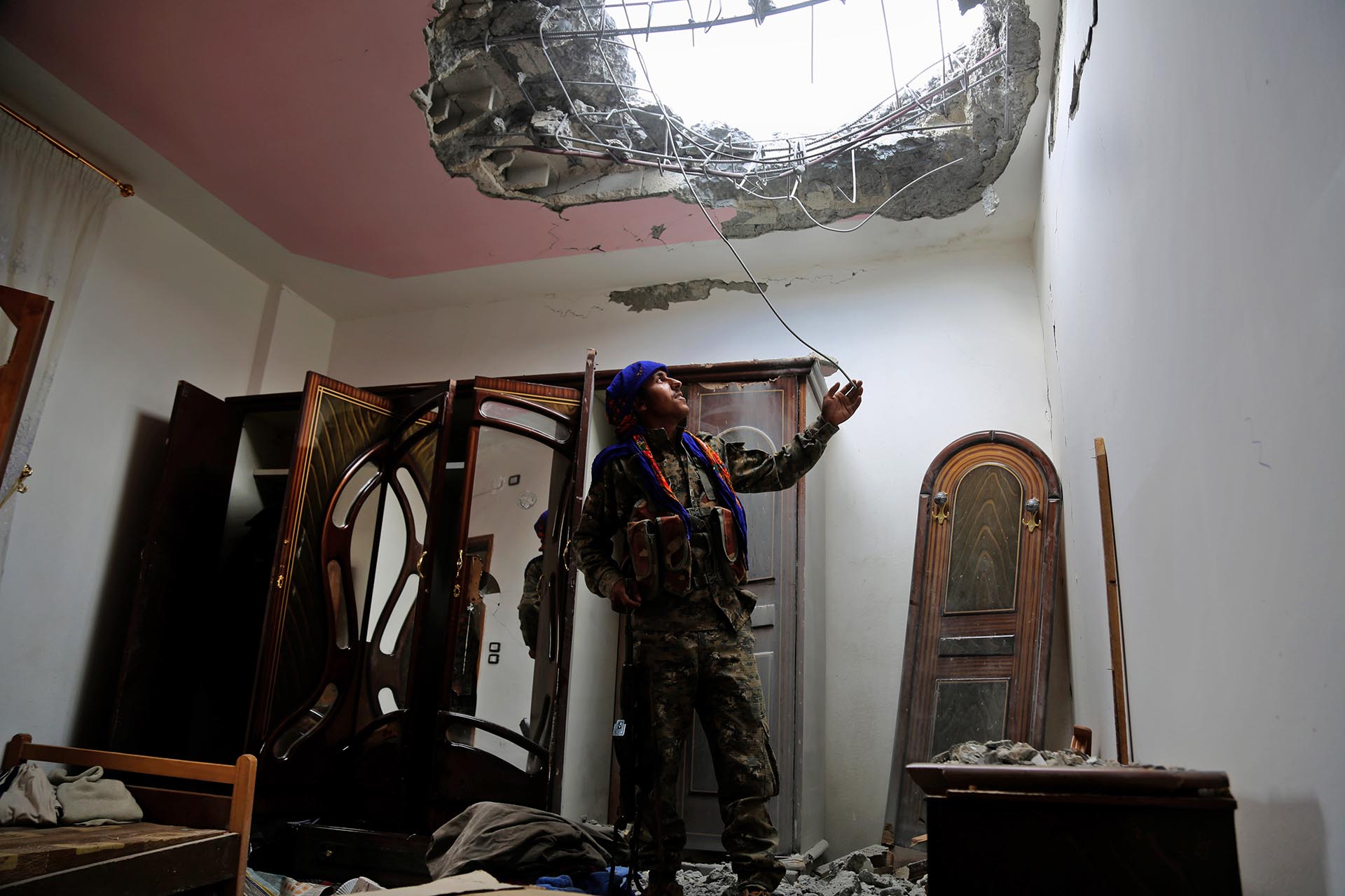 Un miembro de las Fuerzas Democráticas Sirias (SDF), formadas por una alianza de combatientes árabes y kurdos, examina los daños en un barrio del frente oriental de Raqqa, bastión sirio del grupo ISIS, después de sacar del área a los yihadistas en junio
