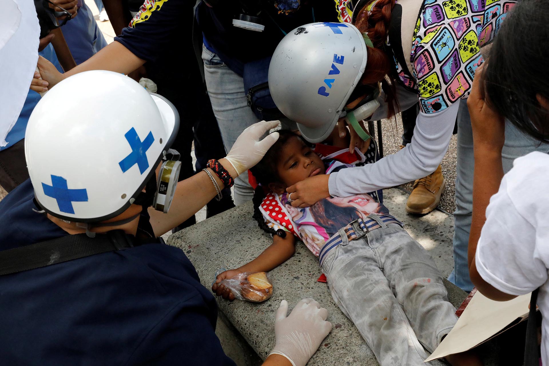 Un niño afectado por gases lacrimógenos es asistido por miembros voluntarios de un equipo de atención primaria durante una manifestación contra el gobierno del presidente de Venezuela, Nicolás Maduro, en Caracas