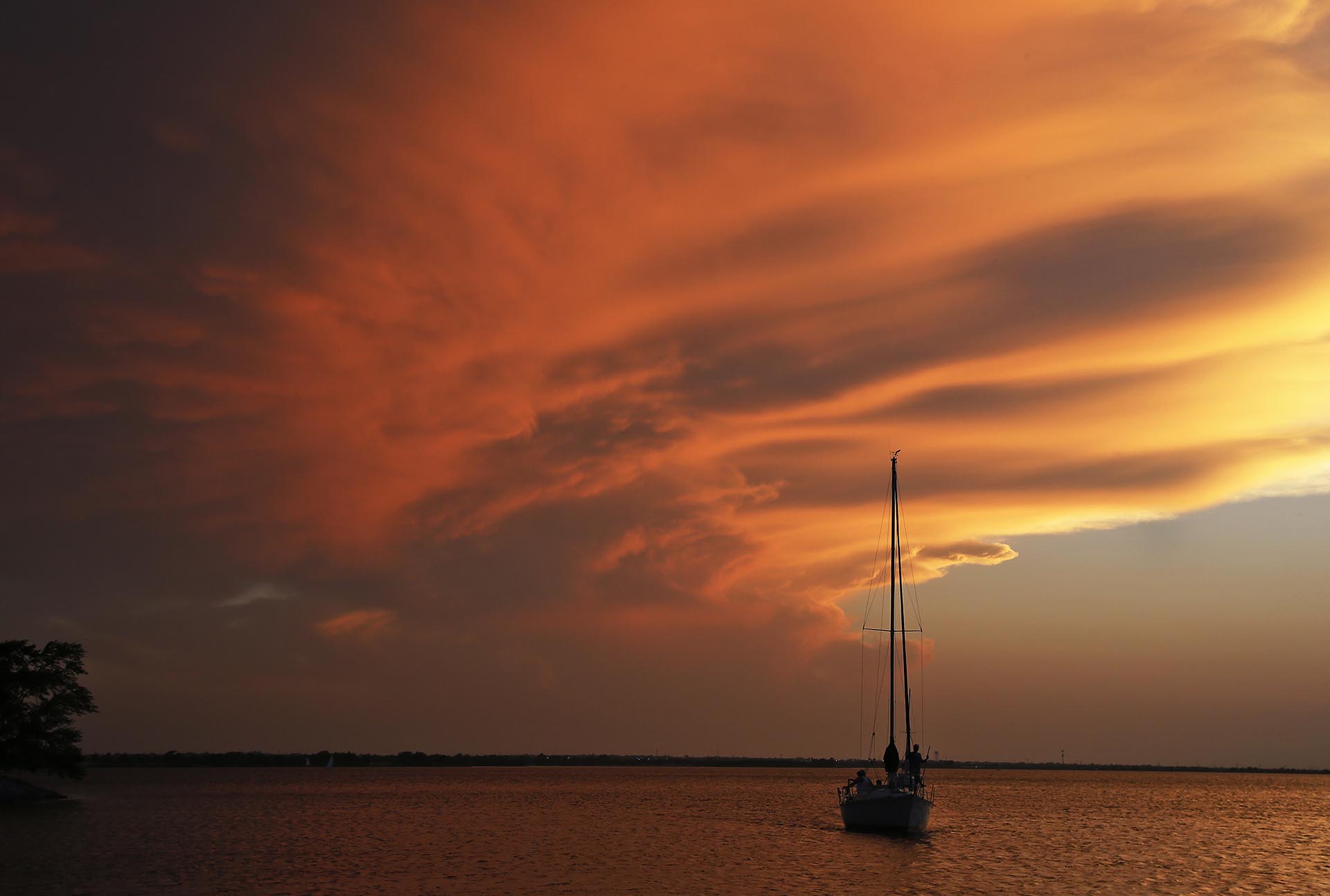 Un barco vuelve al puerto cuando el sol se pone en el lago Hefner en Oklahoma City