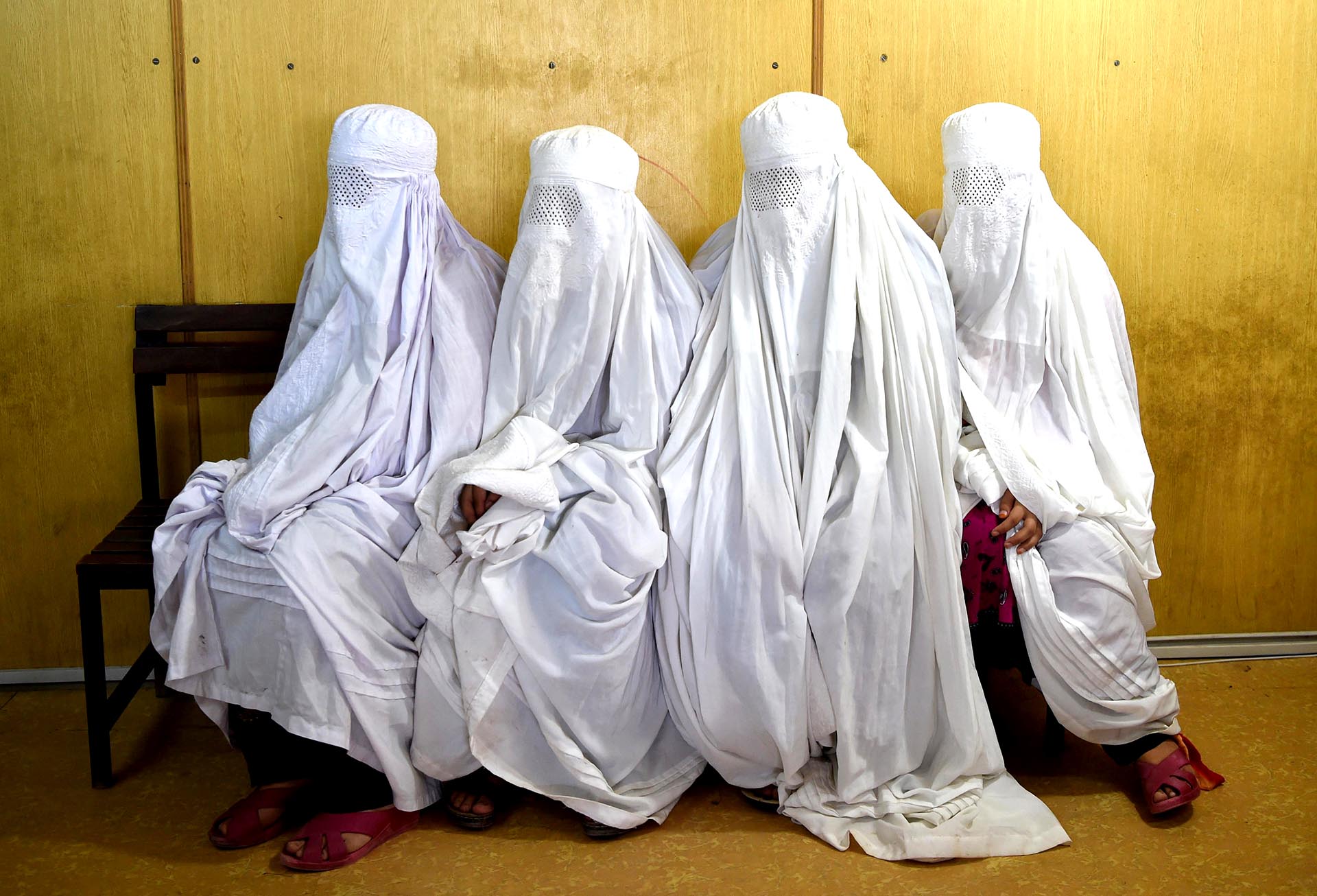 Cuatro refugiadas afganas aguardan ser registradas en Peshawar, Pakistán