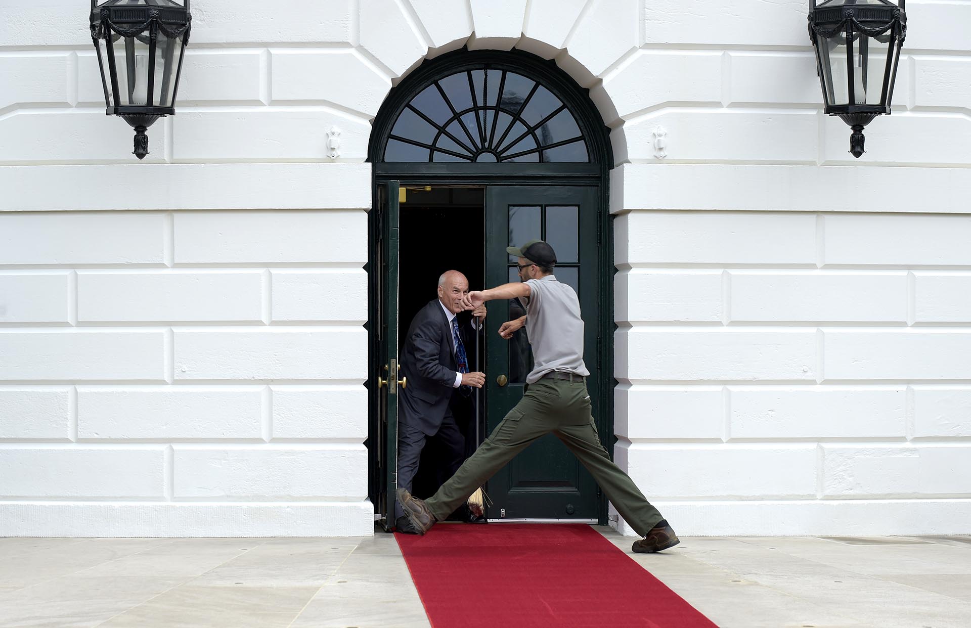 Un trabajador salta por encima de la alfombra roja en la Casa Blanca, antes del encuentro entre el presidente de Estados Unidos, Donald Trump, y el máximo mandatario de Panamá, Juan Carlos Varela, en Washington, Estados Unidos