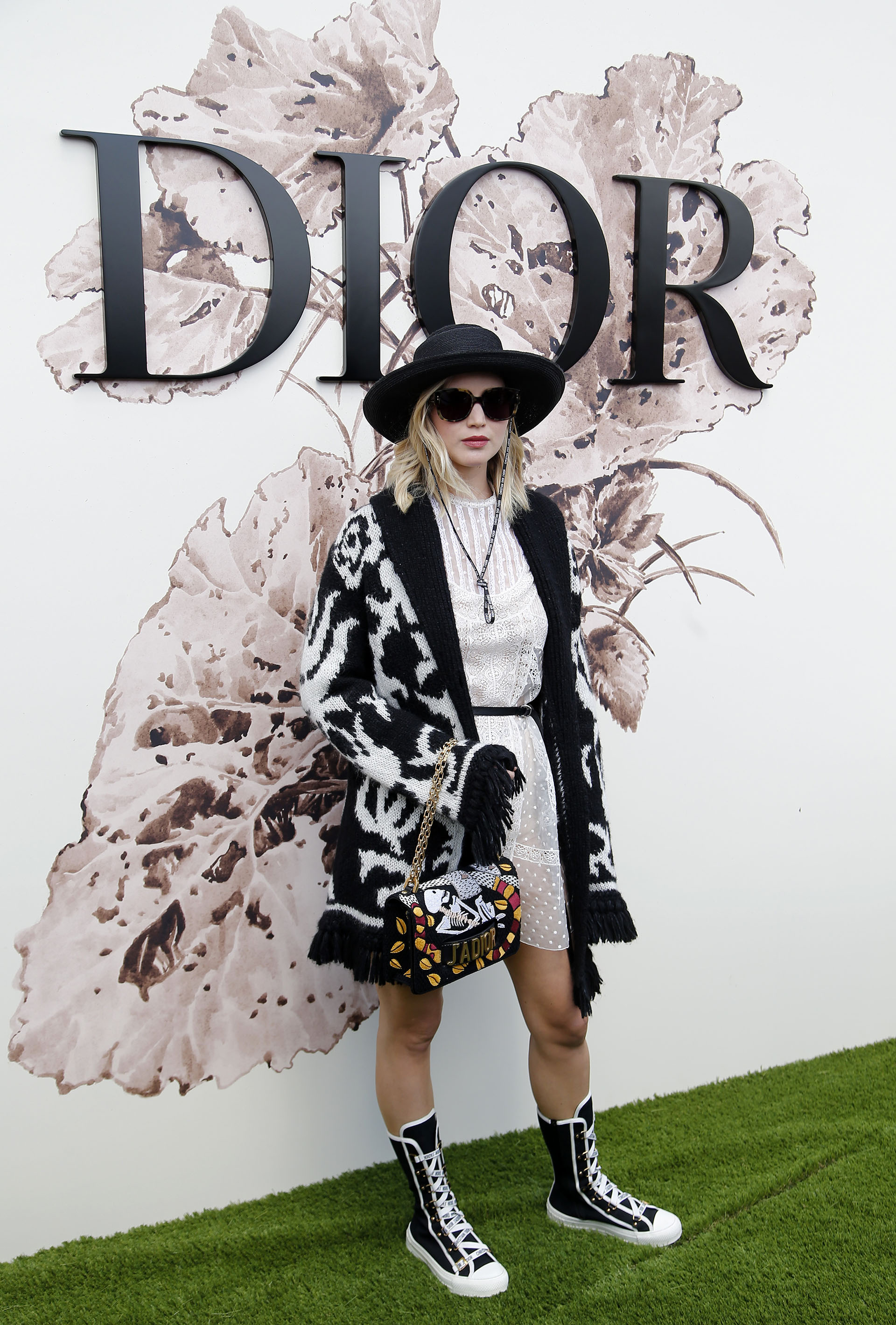 La actriz Jennifer Lawrence optó por un look más casual vestido blanco de encaje abrigo de lana y accesorios Dior (AP Photo/Thibault Camus)