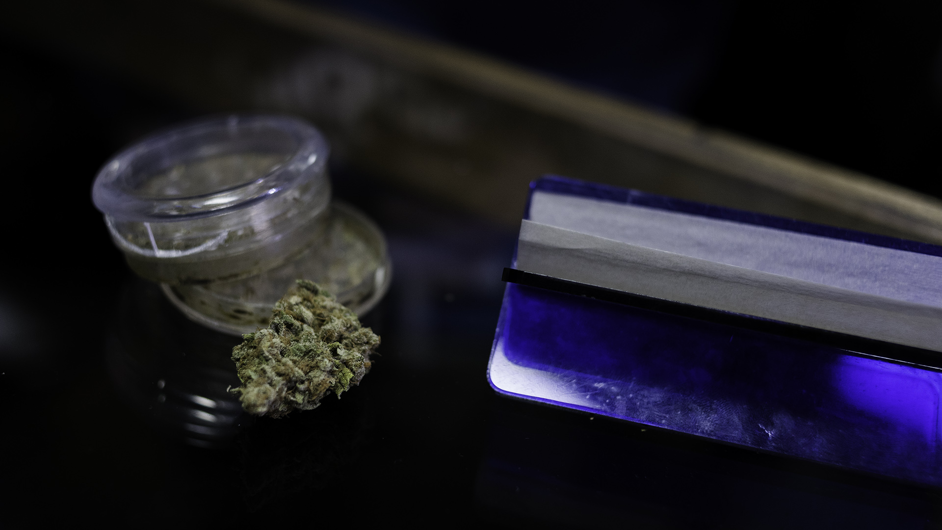 Una flor de cannabis, junto al picador y el papelillo para armar (Adrián Escandar)