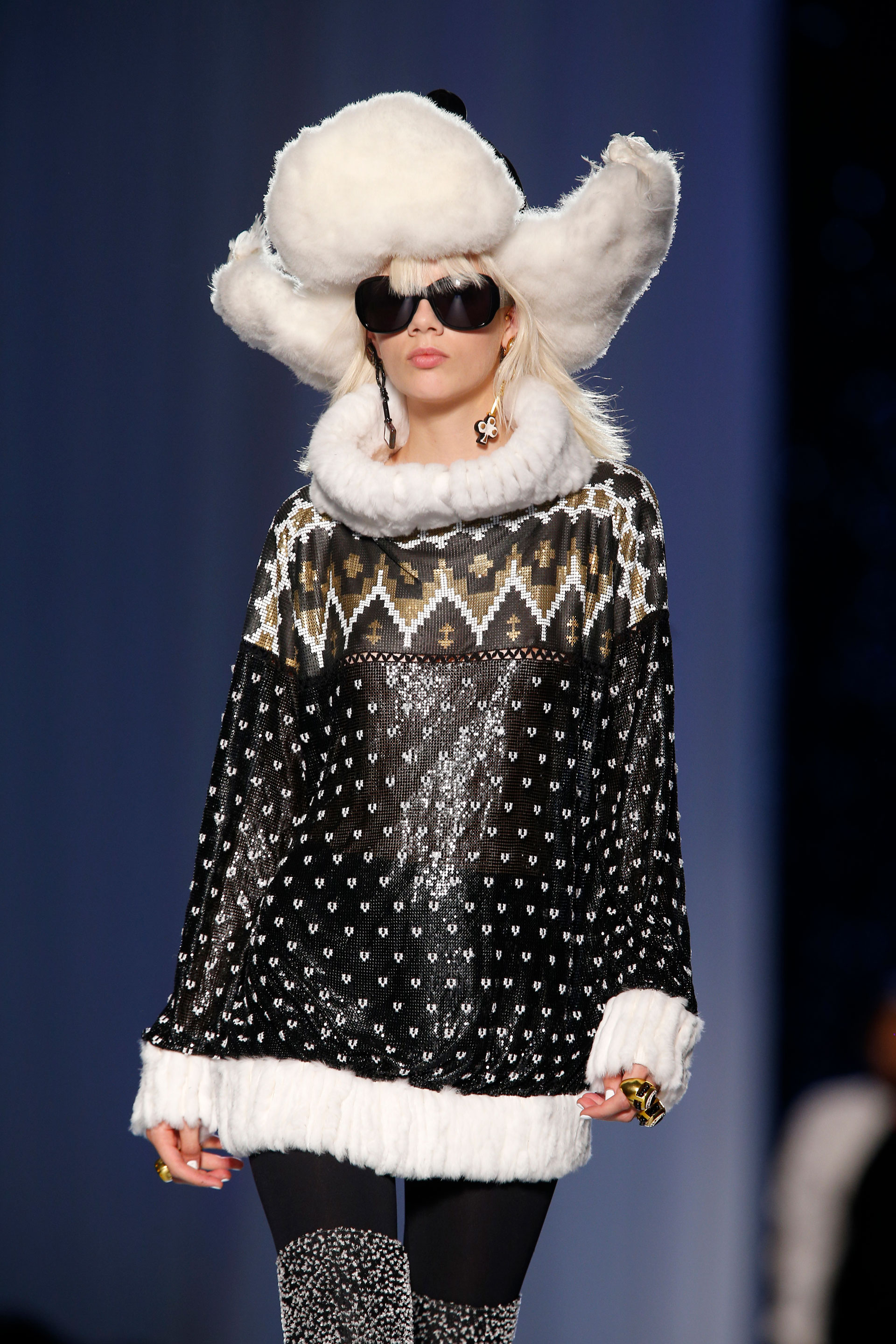 Con el gorro ruso en cuero negro y pelo blanco, maxi sweater en negro con estampado navideño y geometricos con terminaciones en piel (AP)