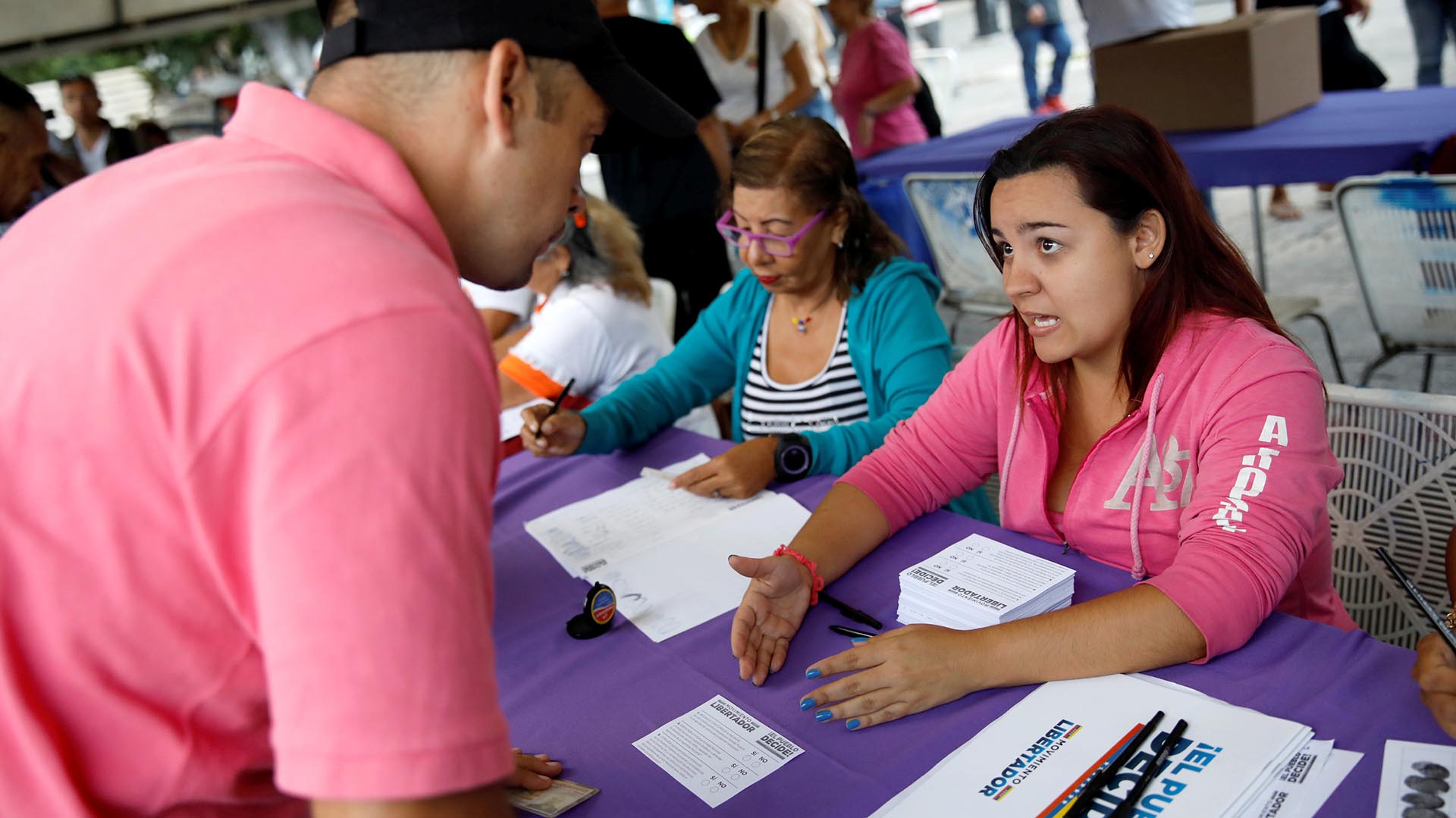 Una mujer explica el funcionamiento de la consulta popular del 16 de julio (Reuters)