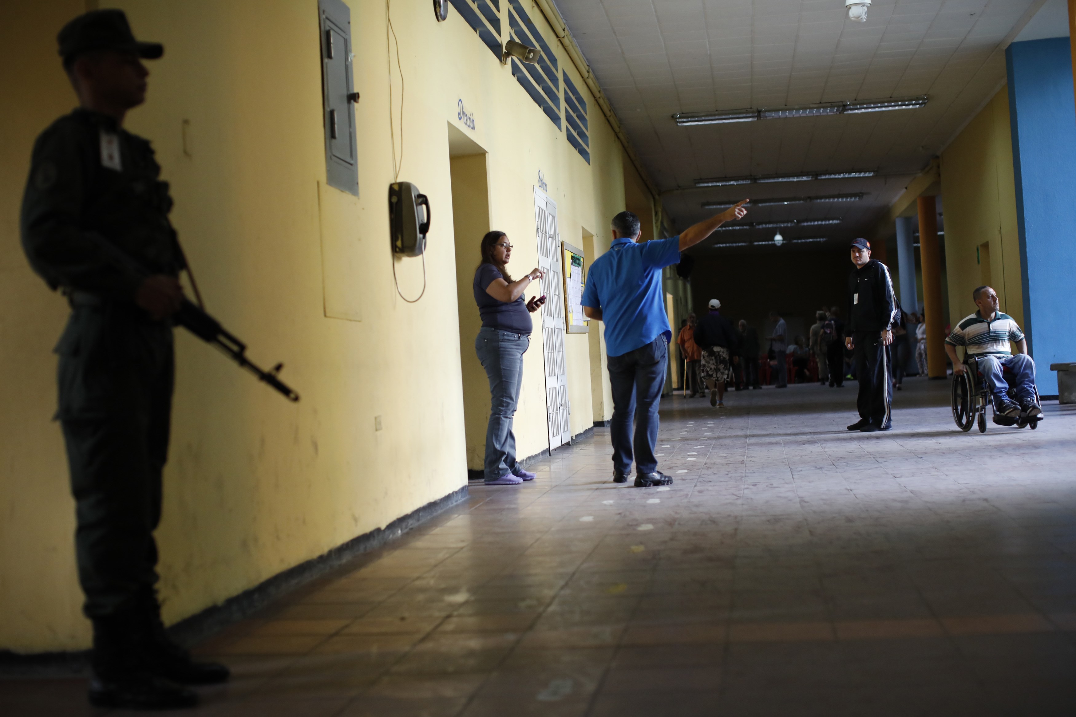 Personas hablan durante la votación, en un centro en Caracas (Reuters)