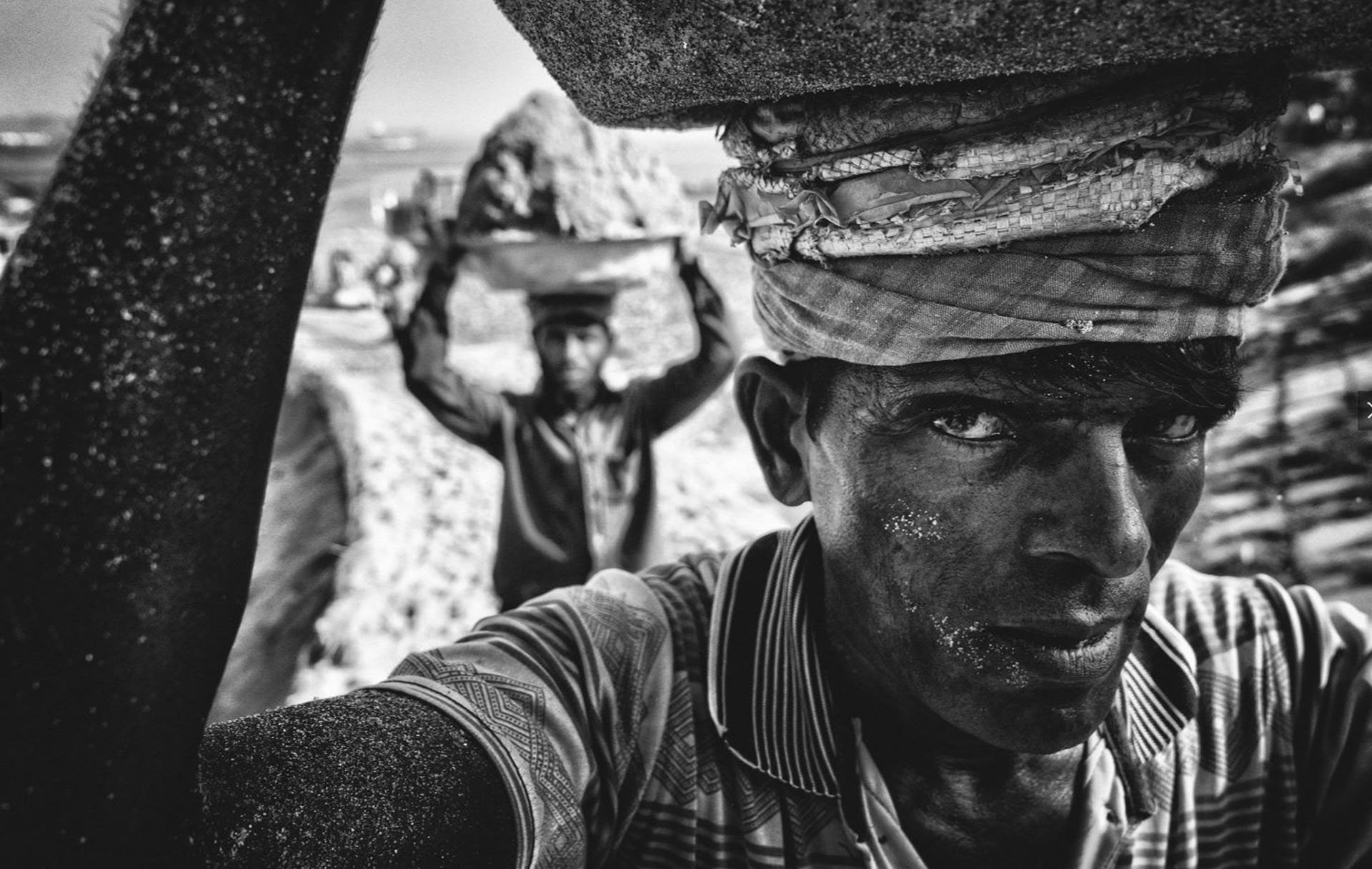 Gente – Voto propular. En Bangladesh, a la orilla del río Dhaleswari, trabajadores cargan arena para presevarla en un lugar cercano. Por Tanveer Hassan Rohan