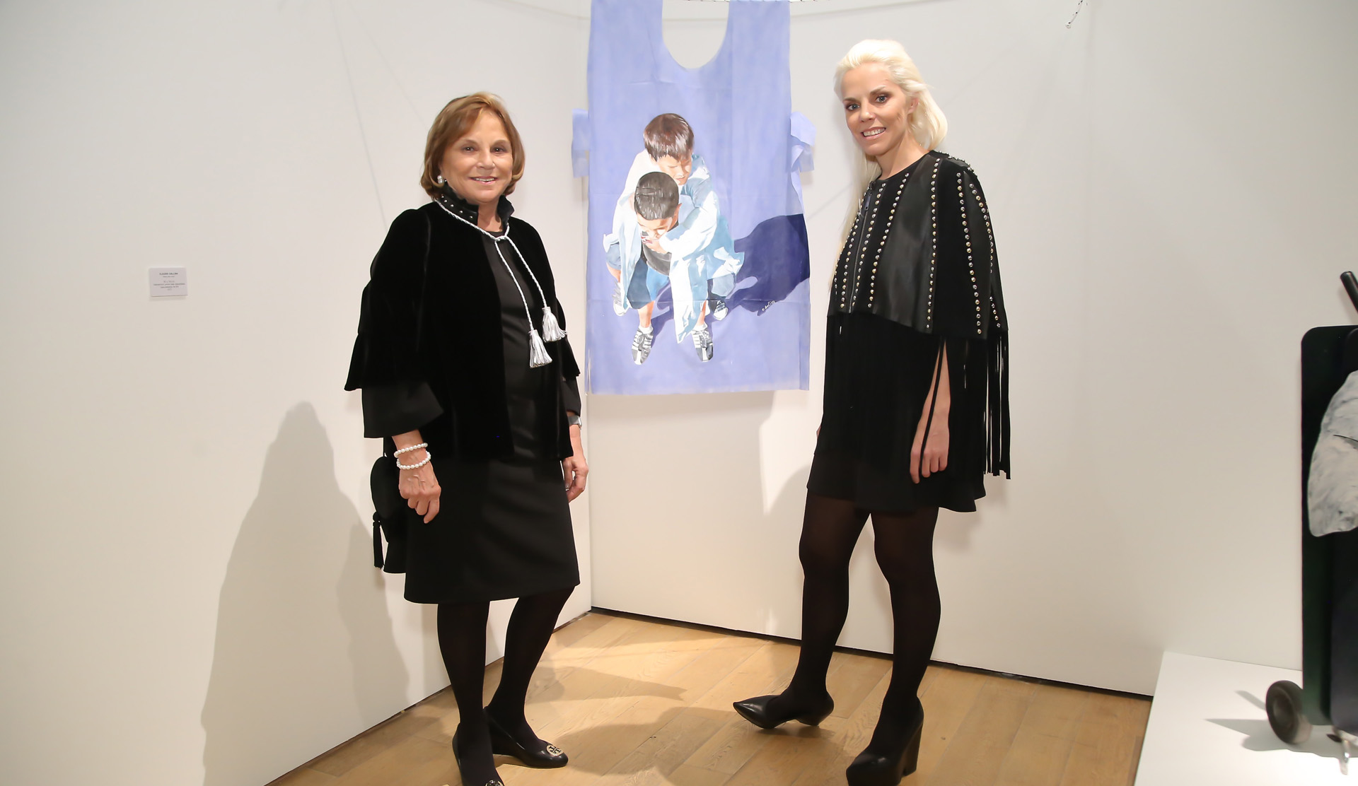 Eugenia Cerdá de Rossi y Agustina Rossi, presidente y directora de Fundación Rossi respectivamente, junto a la obra de Claudio Gallina, que propone que las batas azules descartables salgan del gabinete y entren en un museo