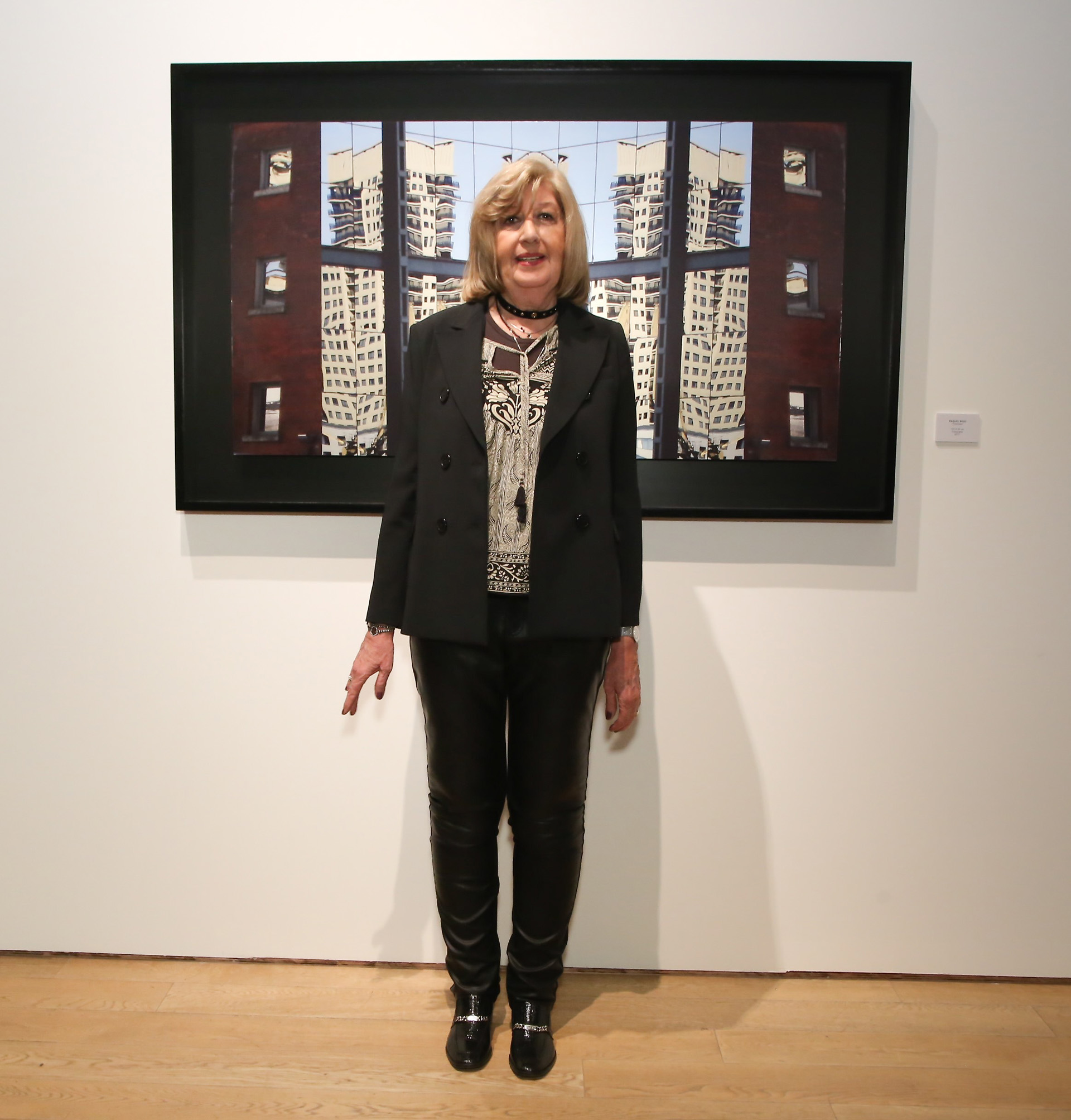 La artista Raquel Bigio posa delante de su obra “Ficciones”, en la que presenta una fotografía donde la mirada queda atrapada por la intensidad del entorno arquitectónico