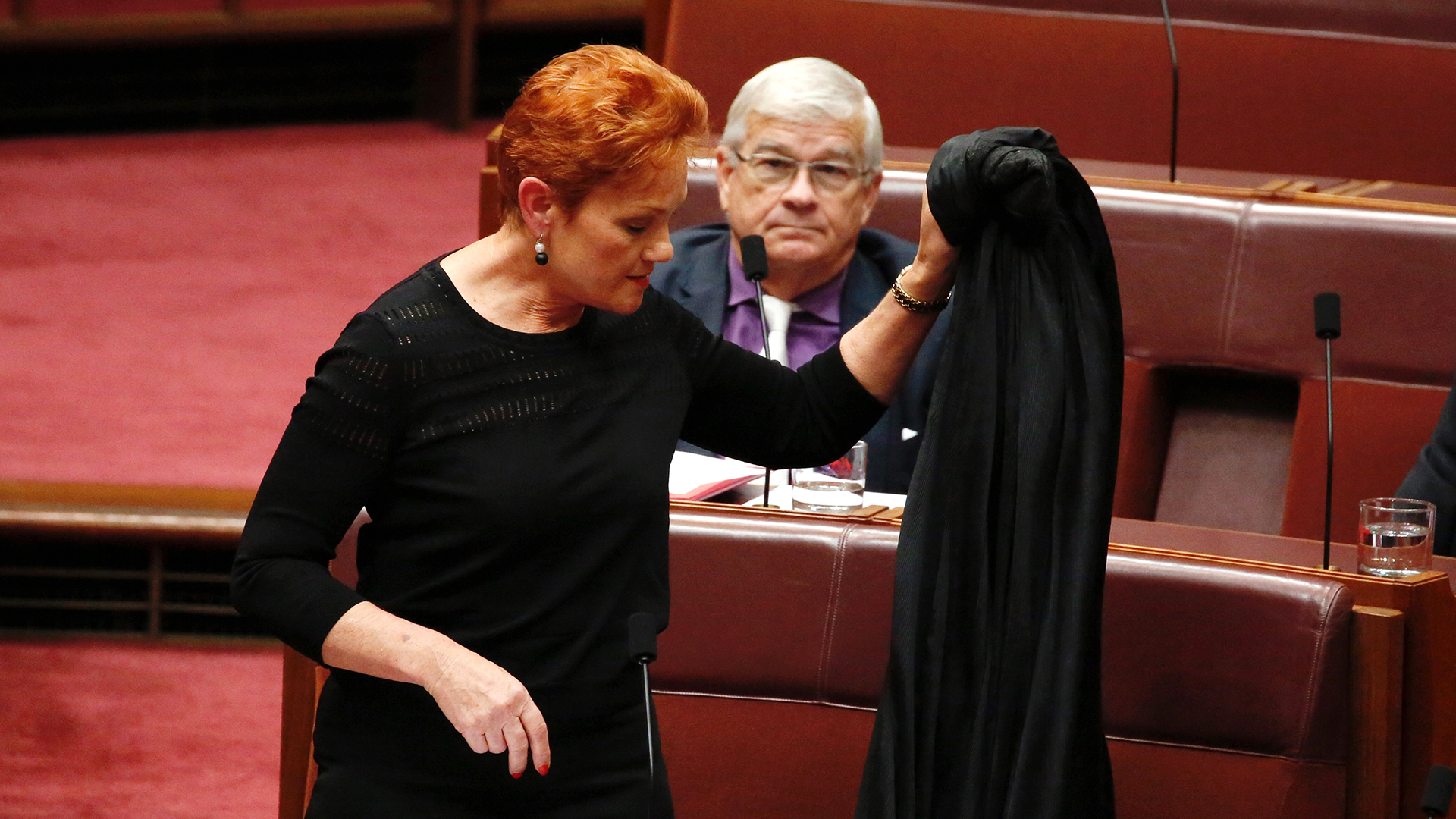 Hanson con la burka en la mano. Pidió al fiscal general George Brandis que trabajara junto a ella en la prohibición de esa vestimental (AP)