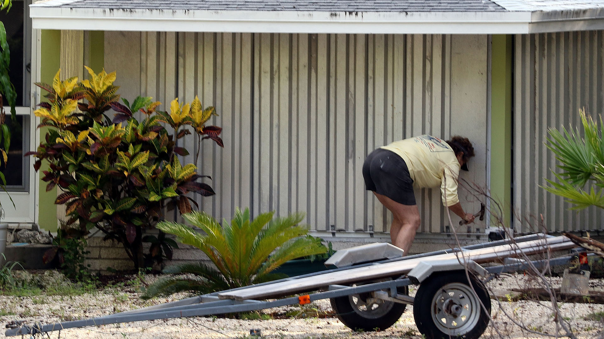 Una mujer asegura el frente de su casa ante la llegada de Irma, e Islamorada, Florida.