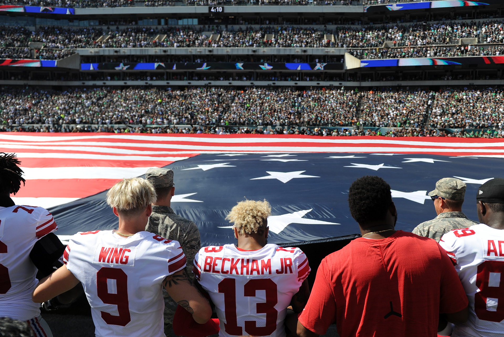 Odell Beckham Jr (13) cruza los brazos con el puntero Brad Wing (9) durante el himno nacional antes del partido contra los Philadelphia Eagles en el Lincoln Financial Field