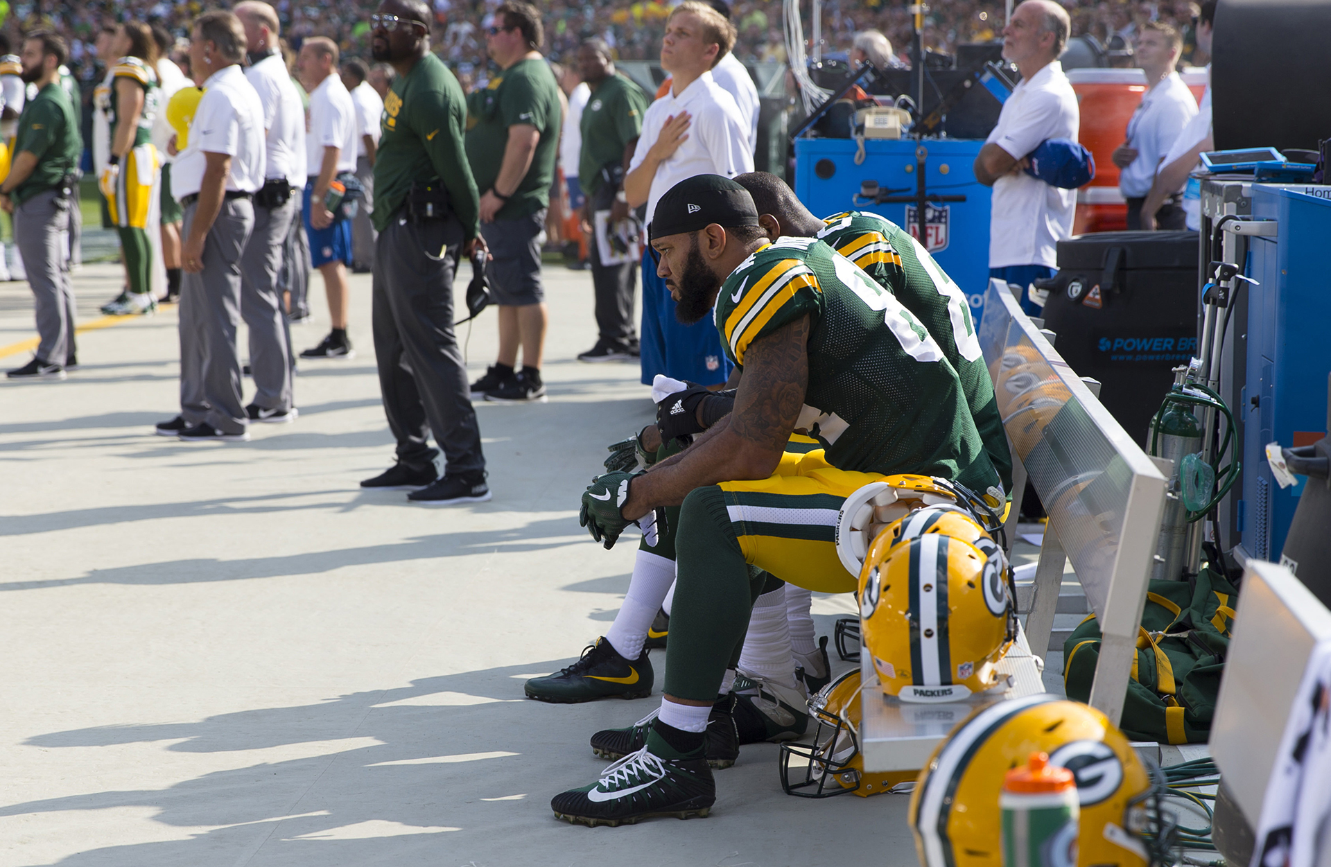 Green Bay Packers: Lance Kendricks (84) y Martellus Bennett (80) se sientan en el banco durante el himno nacional antes del juego contra los Cincinnati Bengals en el campo de Lambeau