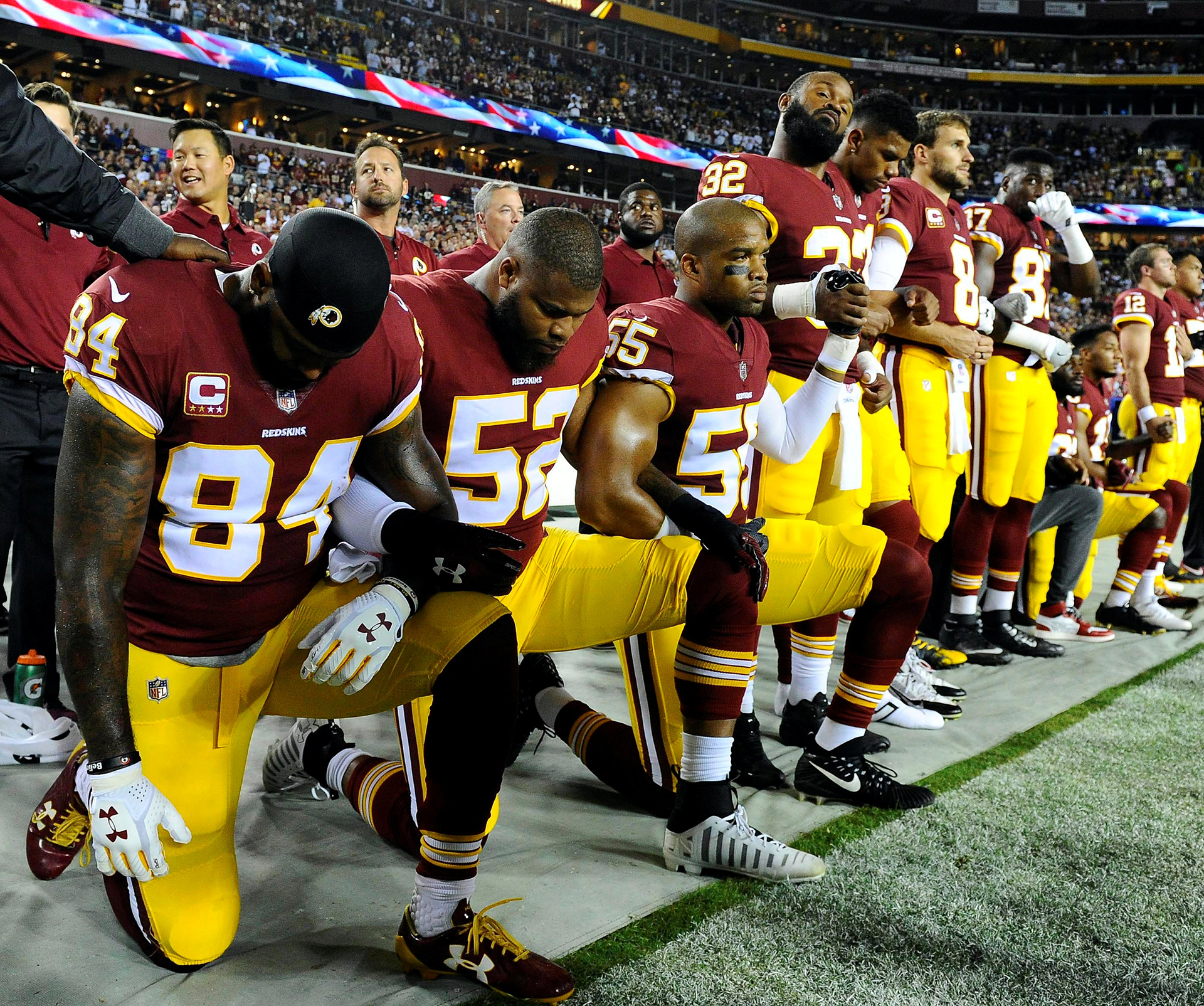 Niles Paul (84) y el apoyador de Washington Redskins Chris Carter (55) se arrodillan con sus compañeros de equipo durante el himno nacional antes del partido entre los Redskins de Washington y los Raiders de Oakland