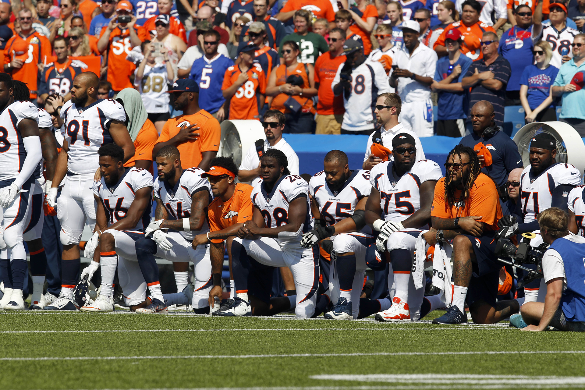 Los jugadores de Denver Bronco se arrodillan en protesta durante el Himno Nacional antes de un partido contra los Buffalo Bills
