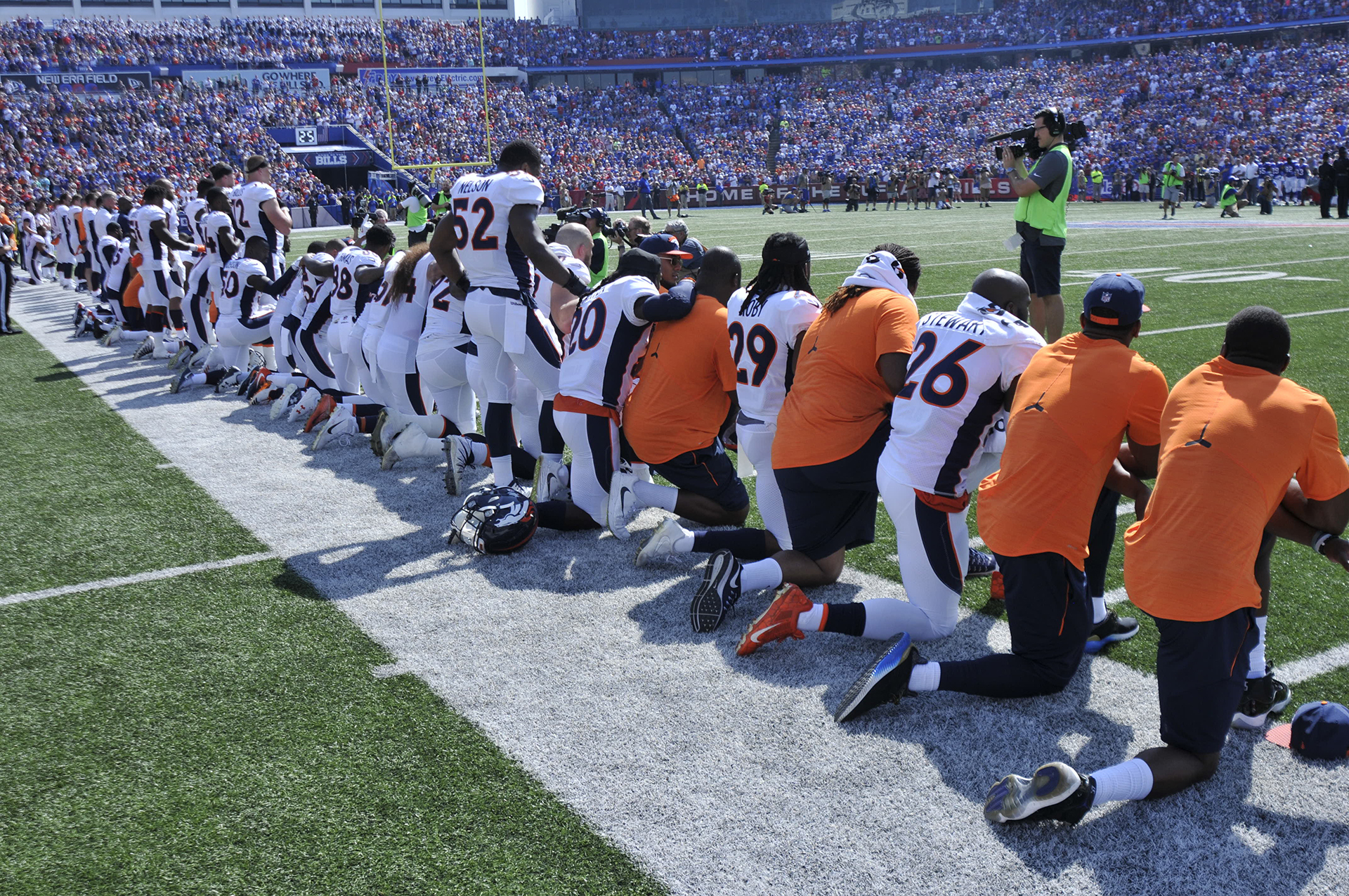 Los miembros de los Denver Broncos se arrodillan durante el juego del himno nacional antes de un partido contra los Buffalo Bills