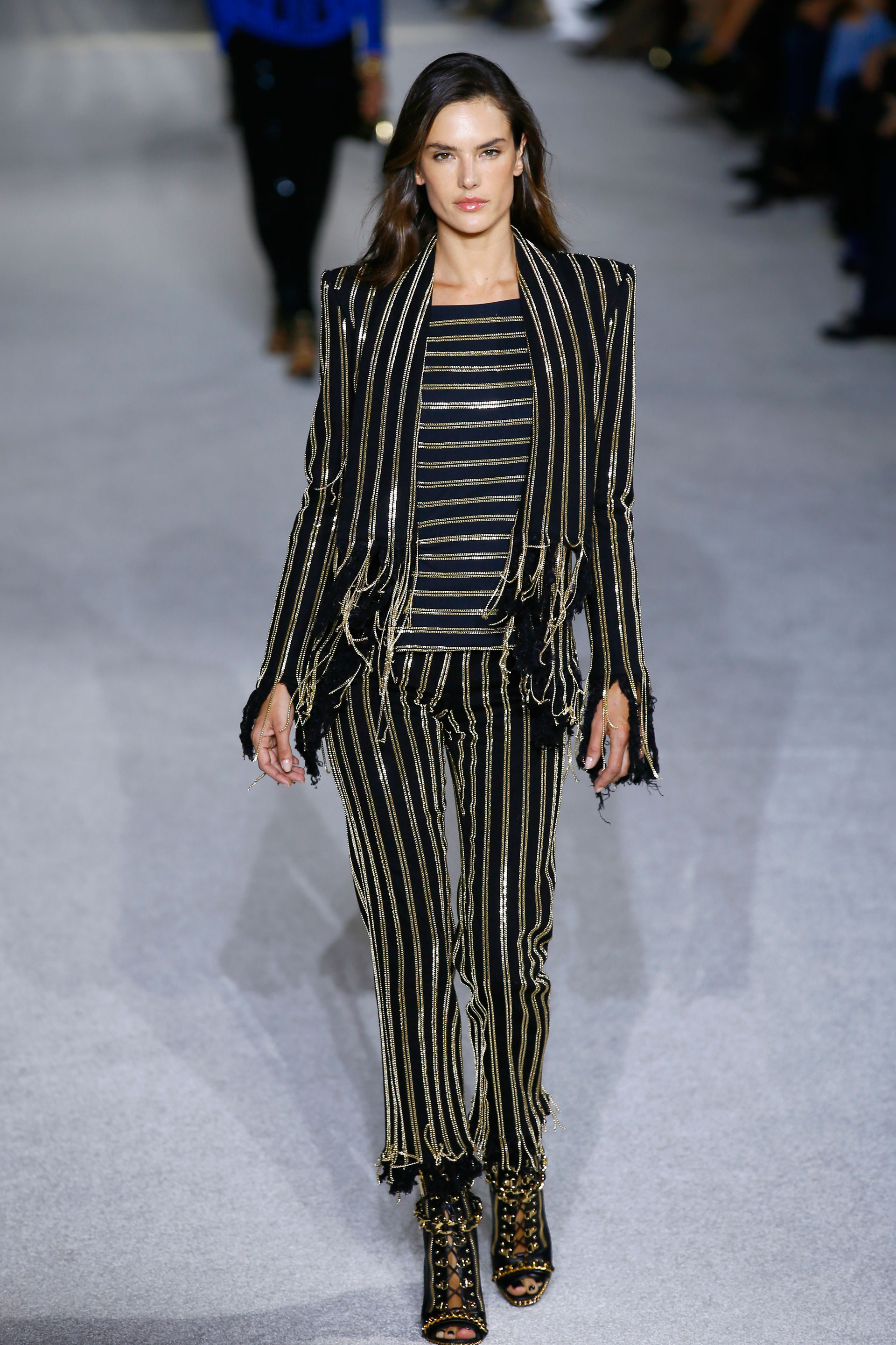 Alessandra Ambrosio, la top model de Victoria’s Secret, subió a la pasarela de Balmain. Rayas verticales y horizontales de cadenas doradas sobre pantalón, camisa y blazer fue su pasada