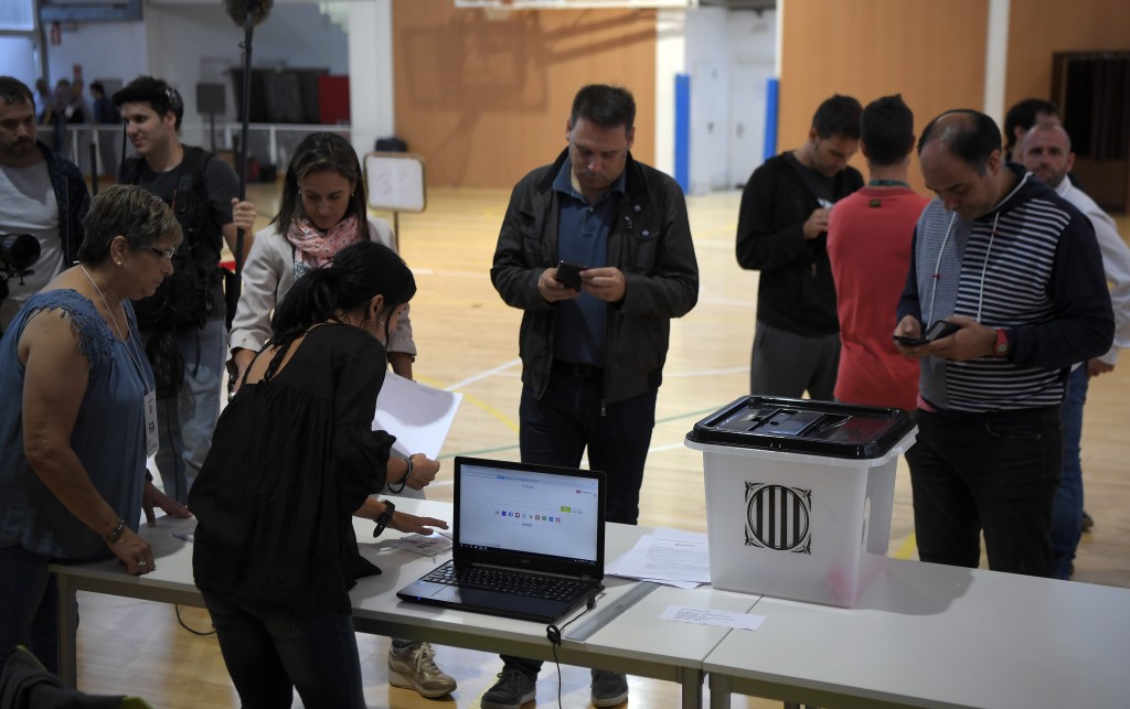 People set up a polling station in Sarria de Ter, where Catalan president will vote, on October 1, 2017, on the day of a referendum on independence for Catalonia banned by Madrid. More than 5.3 million Catalans are called today to vote in a referendum on independence, surrounded by uncertainty over the intention of Spanish institutions to prevent this plebiscite banned by justice. / AFP PHOTO / LLUIS GENE / 