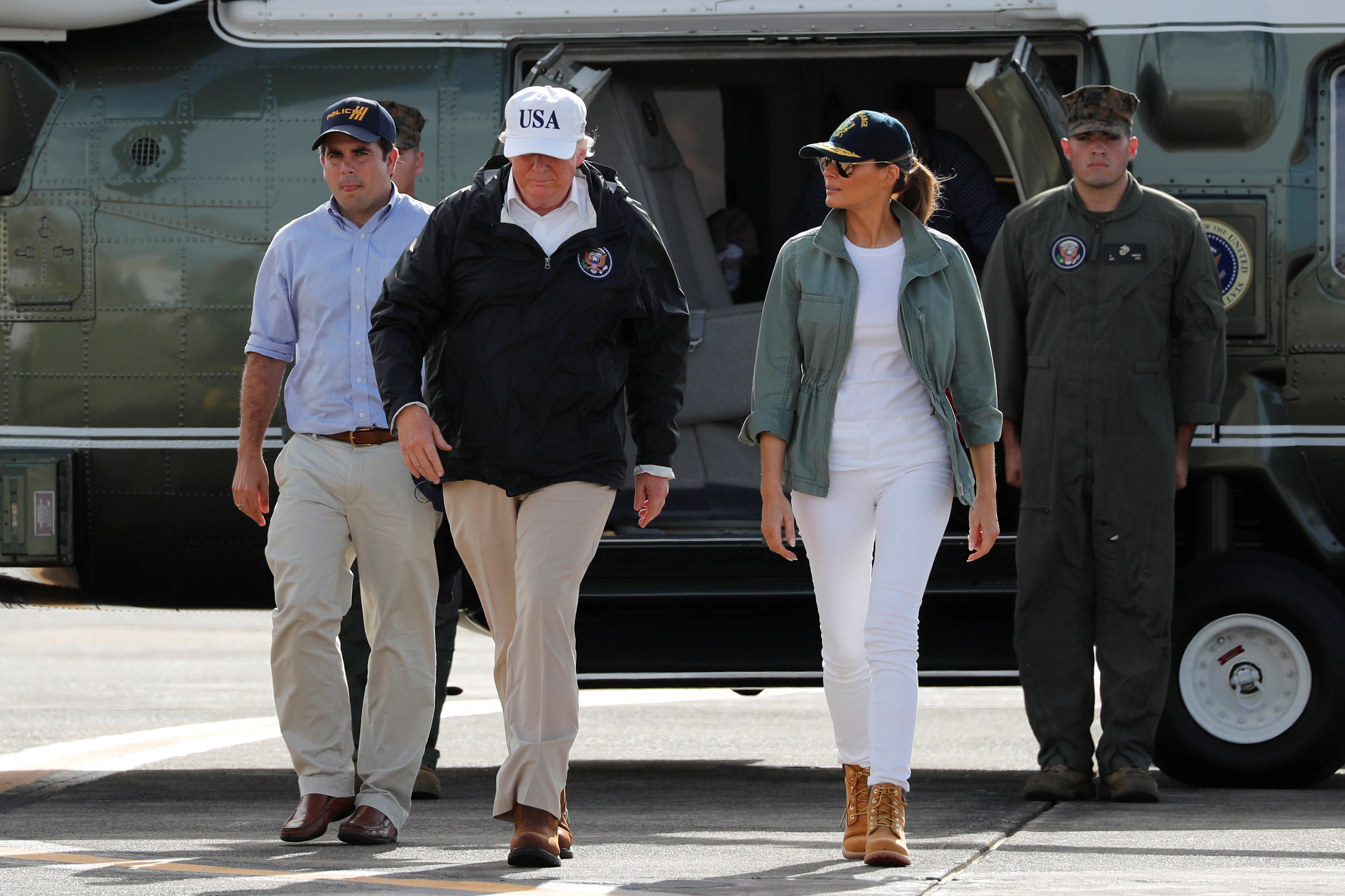 Melania Trump en versión informal, jeans y remera blanca, abrigo militar, borcegos y gorra