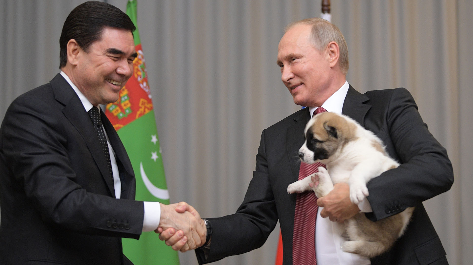 El presidente de Turkmenistán, Gurbanguly Berdymukhamedov (izda.), entrega un cachorro al presidente ruso Vladimir Putin durante su reunión en la residencia de Bocharov Ruchei en el complejo turístico del Mar Negro de Sochi, Rusia, el miércoles 11 de octubre de 2017 (Alexei Druzhinin/Sputnik, Kremlin Pool Photo via AP)