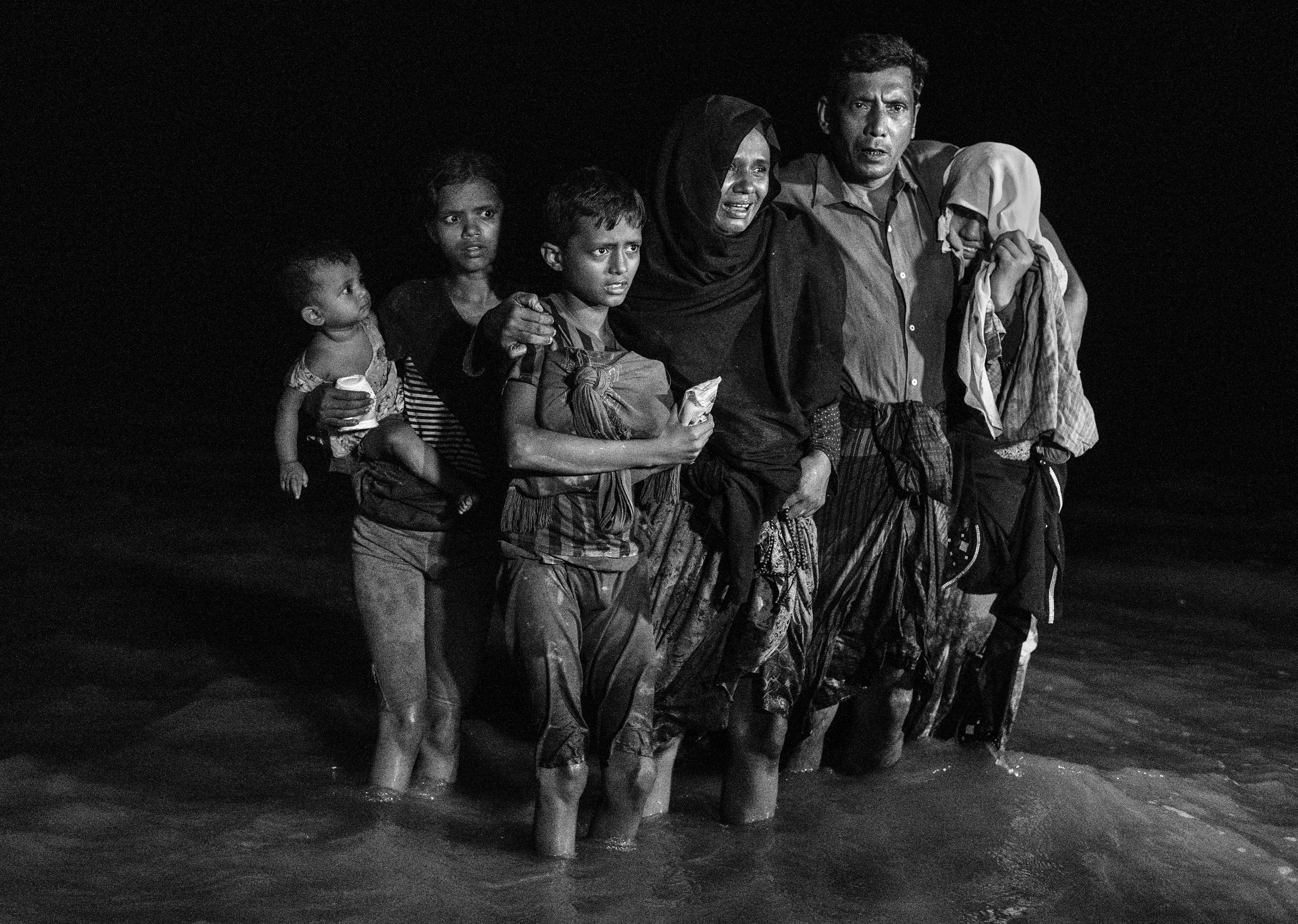 Una familia tras desembarcar en la orilla bangladesí del río Naf (Kevin Frayer/Getty Images)