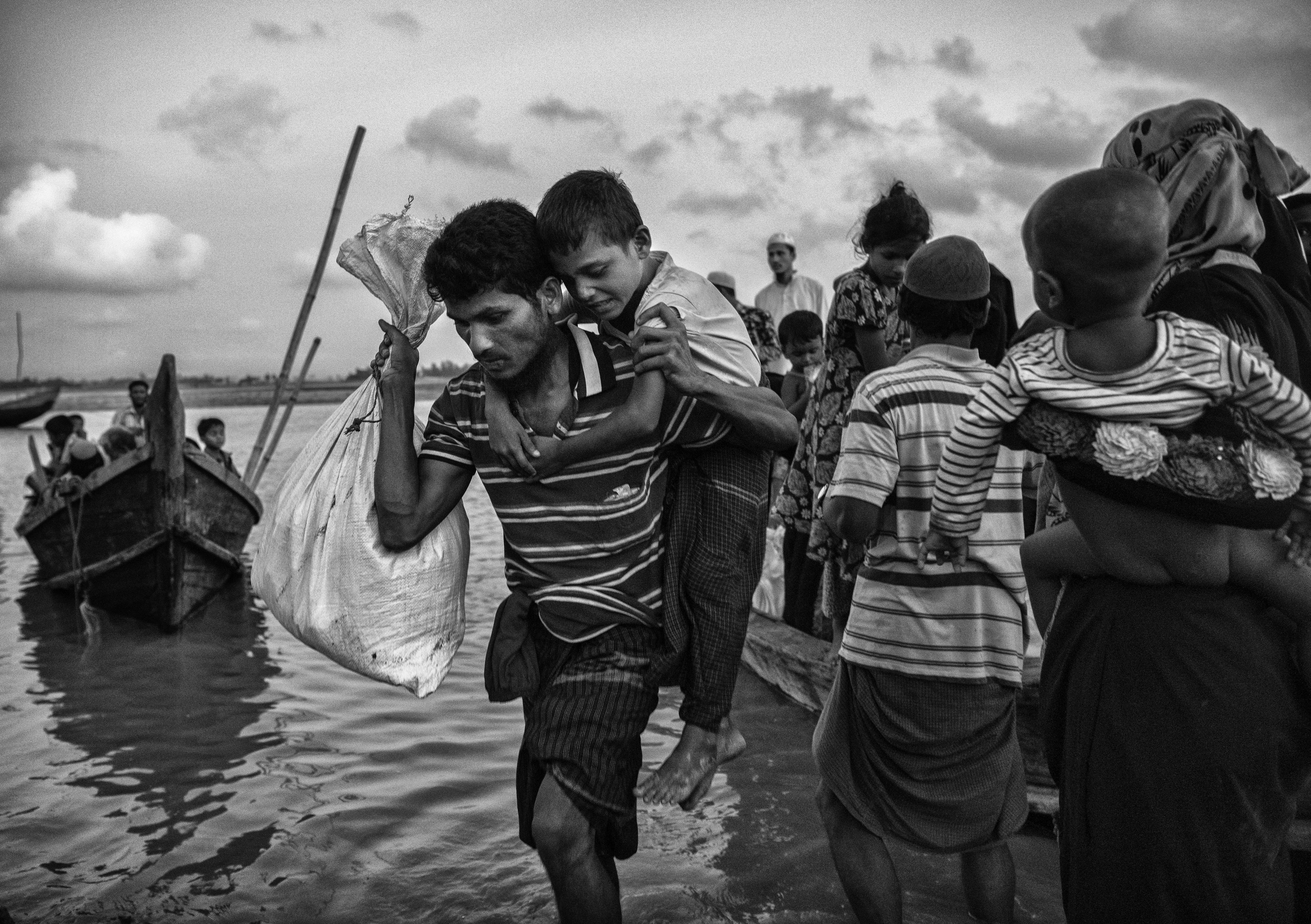 Un hombre y un niño al llegar a la playa del río Naf, en Shah Porir Dwip (Kevin Frayer/Getty Images)