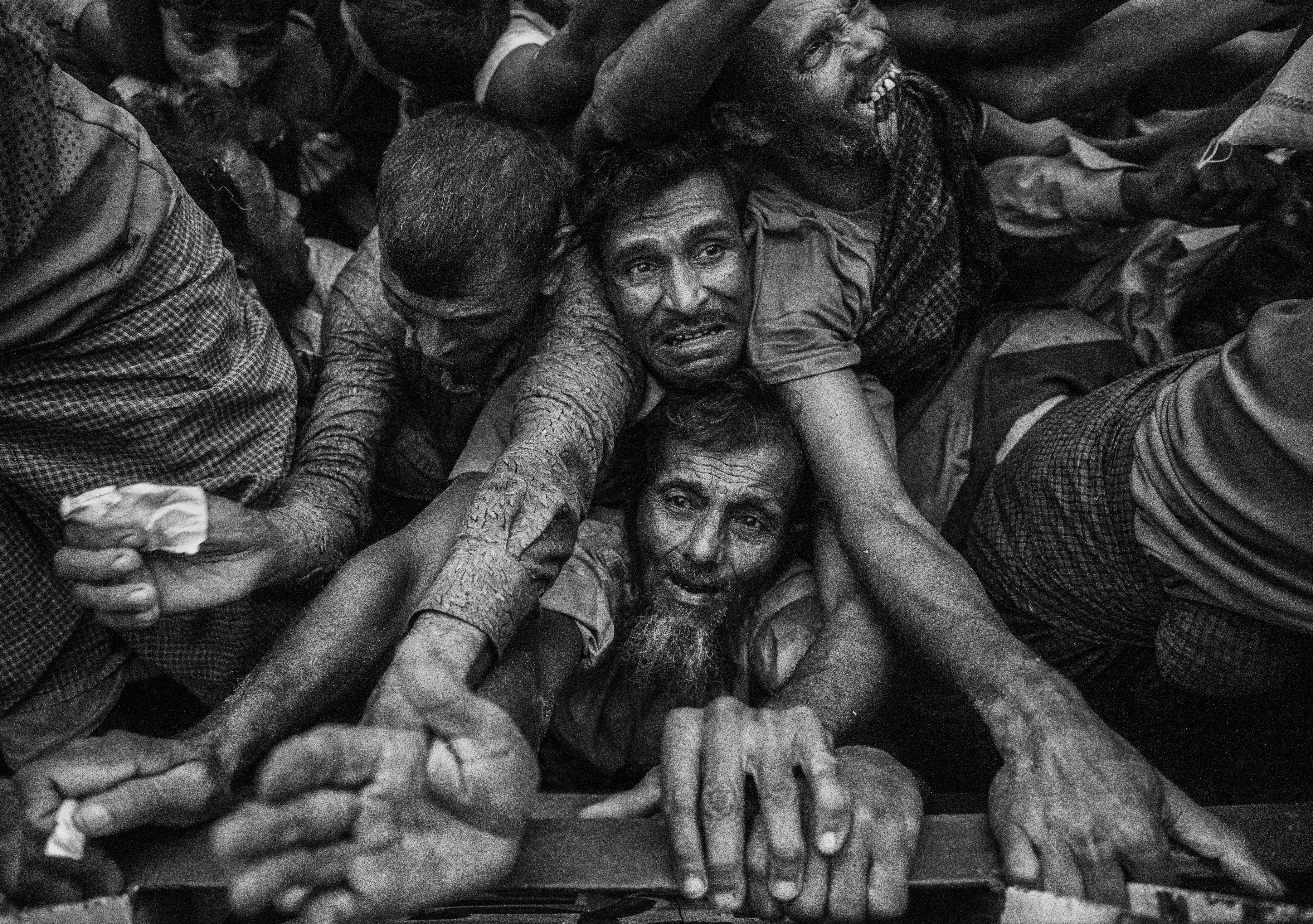 La desesperación de unos hombres durante la distribución de comida en un campo de refugiados (Kevin Frayer/Getty Images)