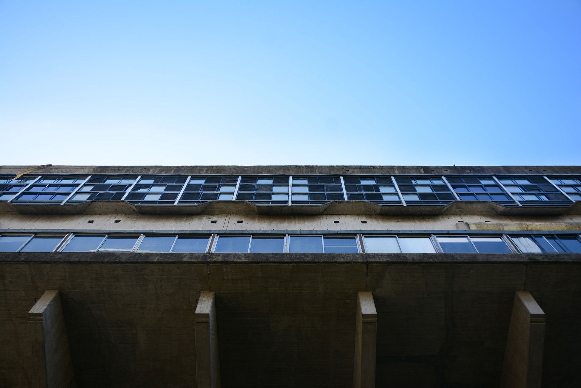 Sobre el terreno que perteneciera a la quinta Unzué -ex residencia presidencial-, irrumpe con notable potencia expresiva la arquitectura ‘brutalista’ de esta pieza arquitectónica única, en el recinto verde conformado y contrastado por los densificados bordes edilicios urbanos