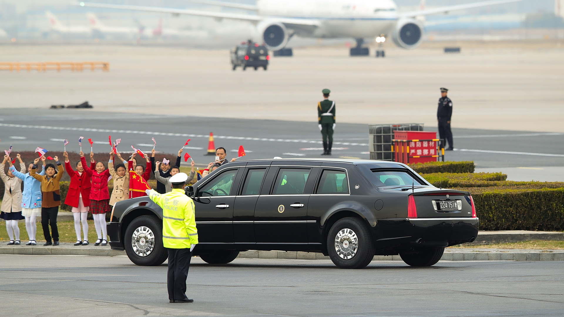 Niños chinos saludan a la Bestia, el Cadillac presidencial que transportará a Donald Trump y a Melania en su gira por Asia (Lintao Zhang/Getty Images)