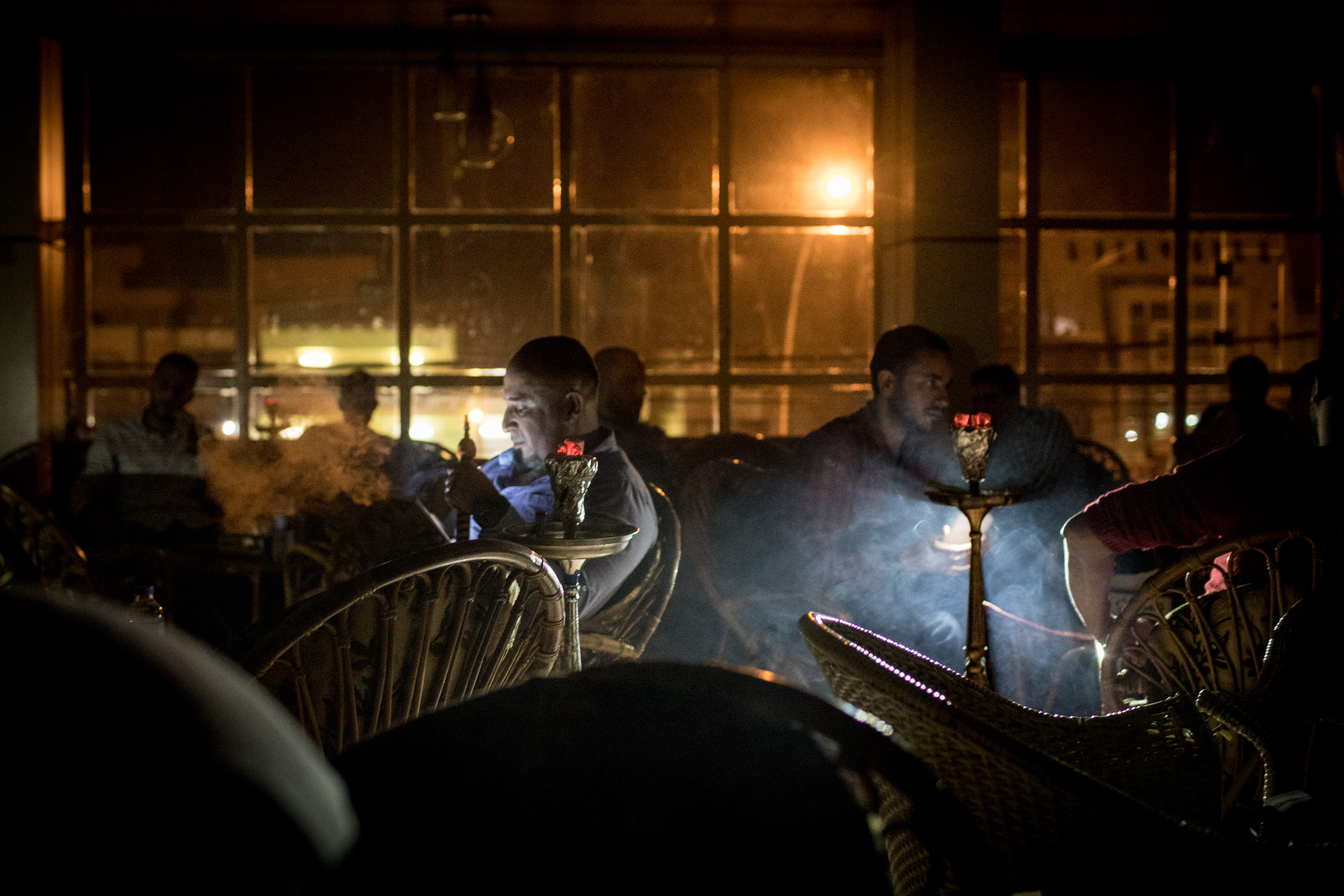 Hombres fuman en un café durante un corte de luz (Chris McGrath/Getty Images)