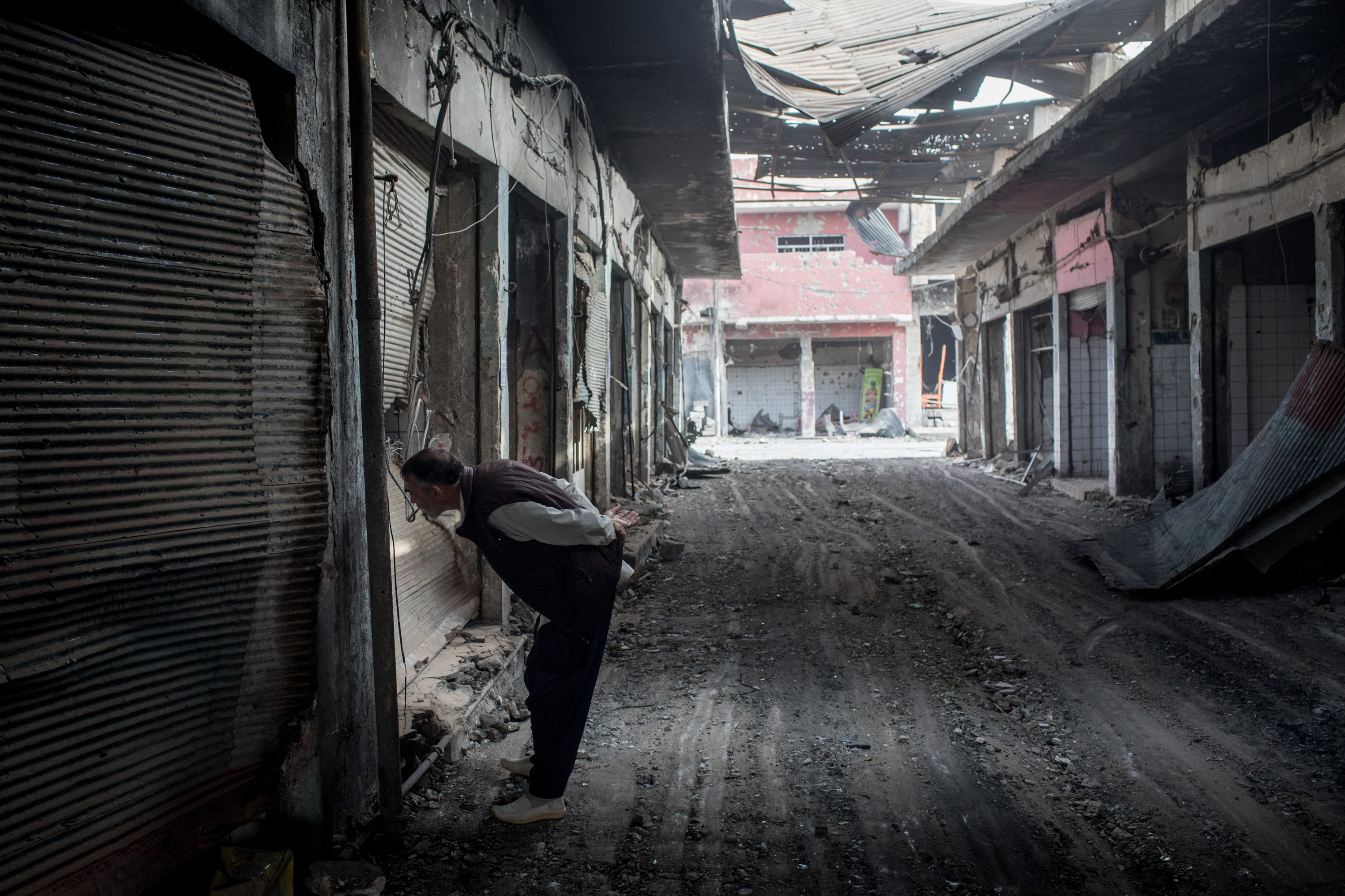 Un hombre mira una tienda destruida en el casco antiguo de la ciudad (Chris McGrath/Getty Images)