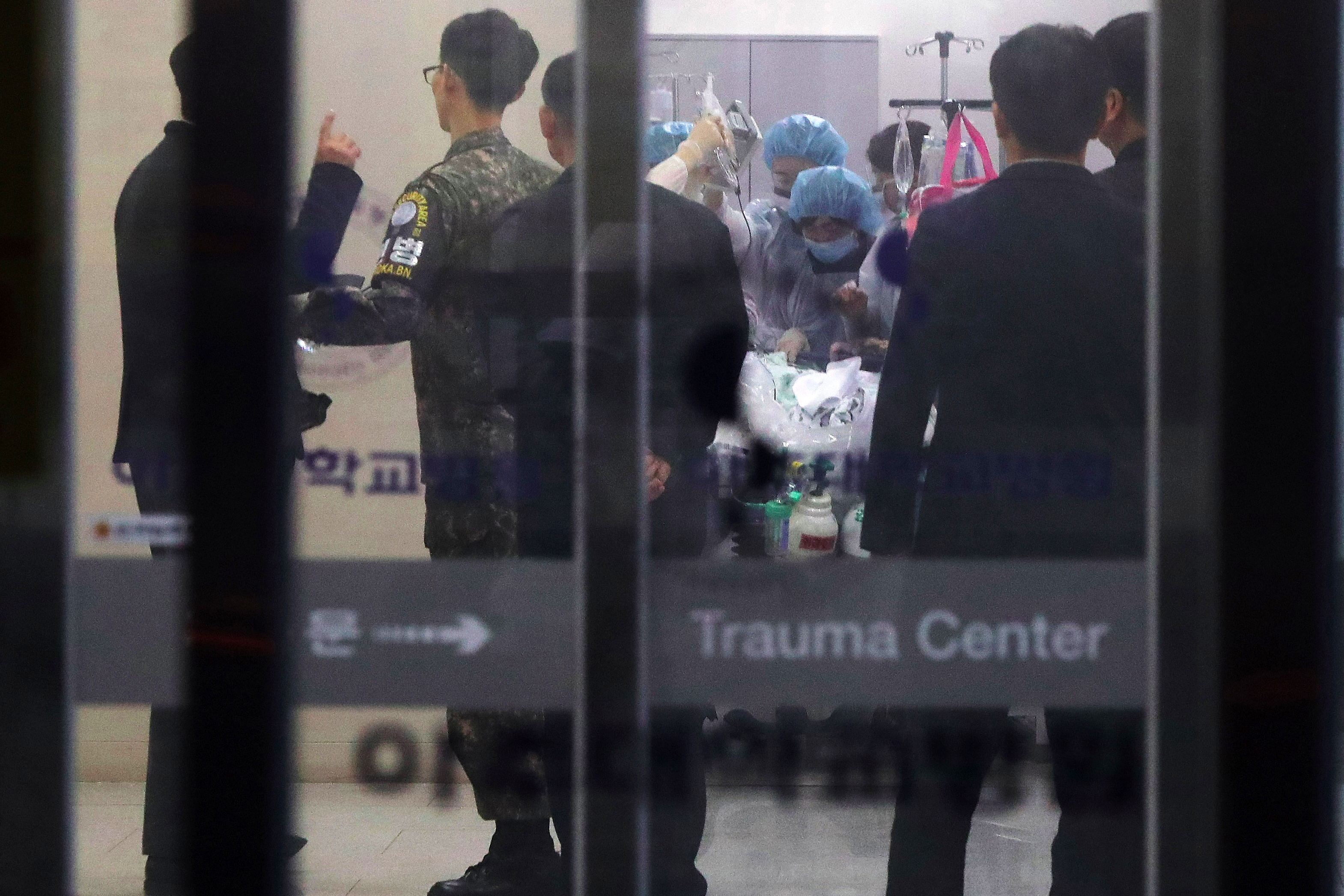 Un militar surcoreano, que lleva un brazalete de la Zona de Seguridad Conjunta de Panmunjom, observa mientras los médicos tratan al soldado norcoreano que desertó, en un hospital de Suwon, al sur de Seúl, el 13 de noviembre de 2017. (AFP)
