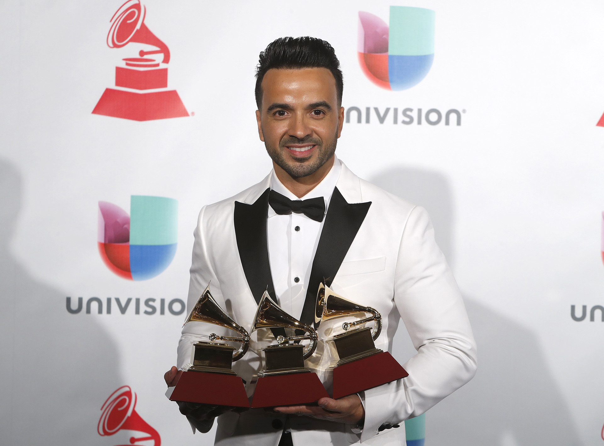 Luis Fonsi sostiene los tres premios por Canción del Año, Grabación del Año y Fusión/Interpretación Urbana por “Despacito” (REUTERS/Steve Marcus)