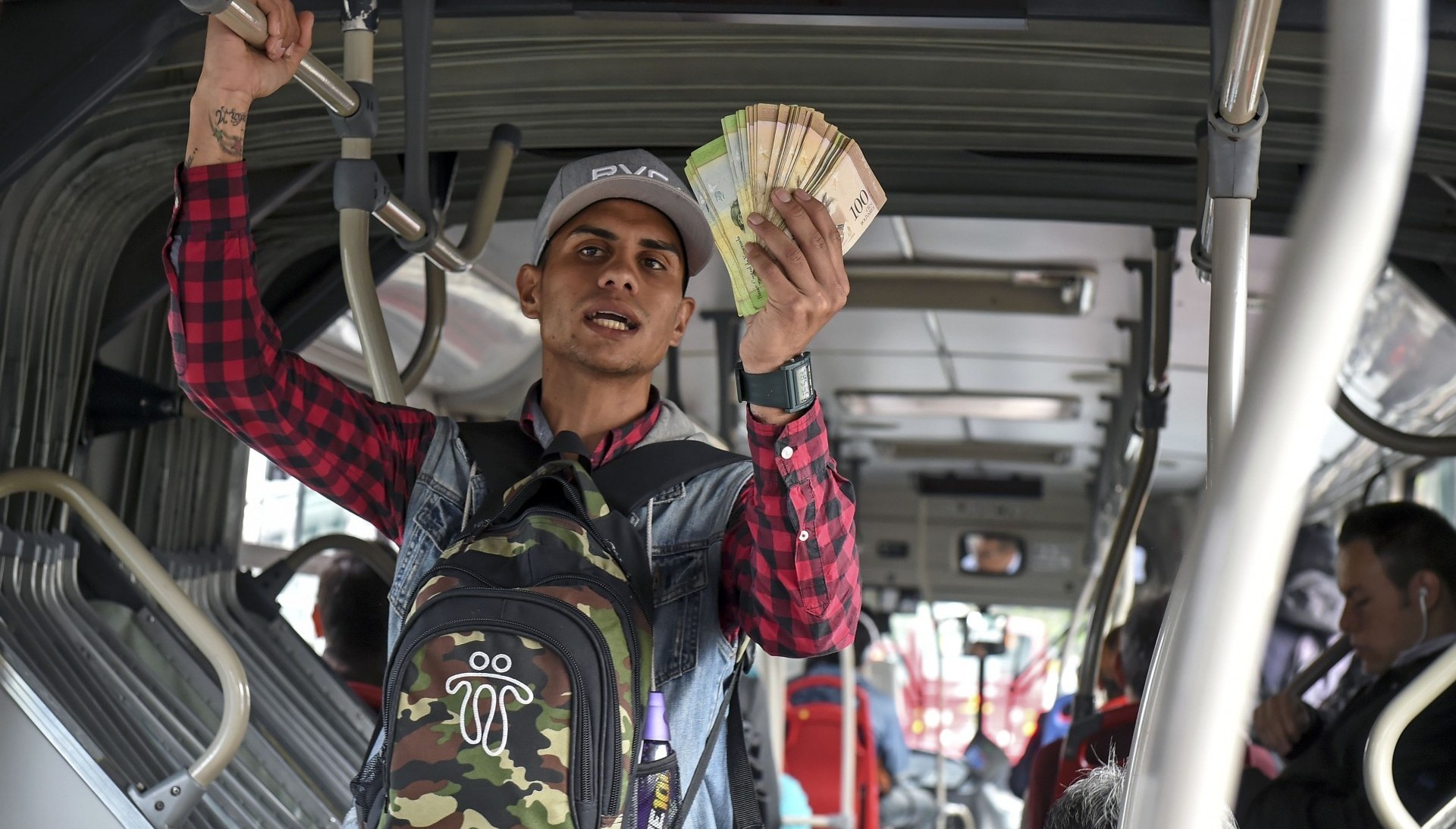 Un joven venezolano vende en Bogotá sus billetes, casi sin valor, por alguna moneda (AFP)