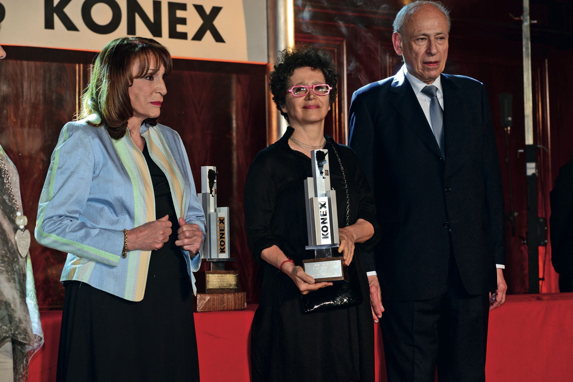 Uno de los momentos más emotivos de la velada: Victoria Verlichak –aquí entre Magdalena Ruiz Guiñazú y Luis Ovsejevich– se lleva el Konex de Honor en memoria de su marido, el periodista Pepe Eliaschev, fallecido hace tres años. Foto: Diego Soldini/GENTE